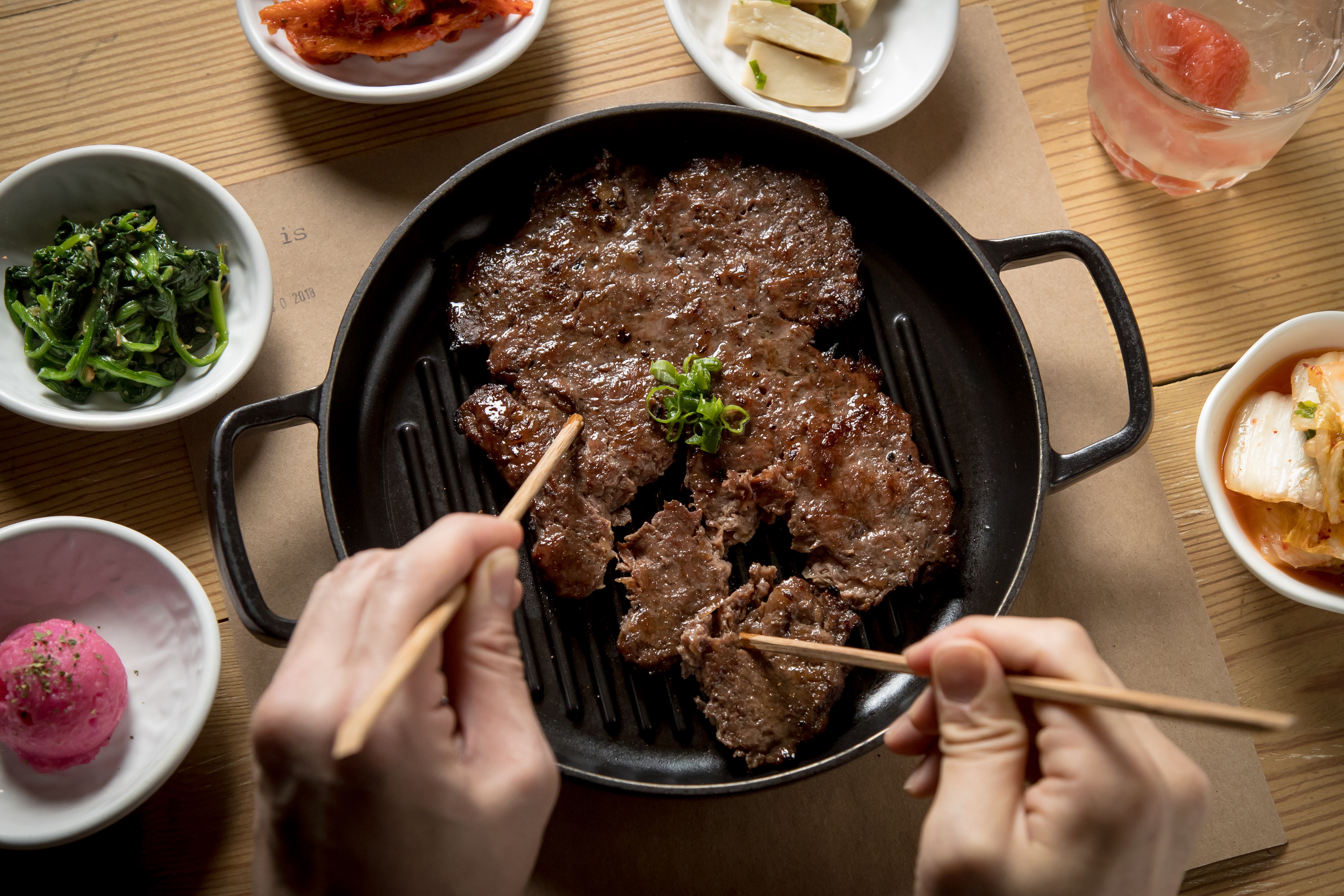 Fire-grilled bulgogi, being pulled apart by chopsticks