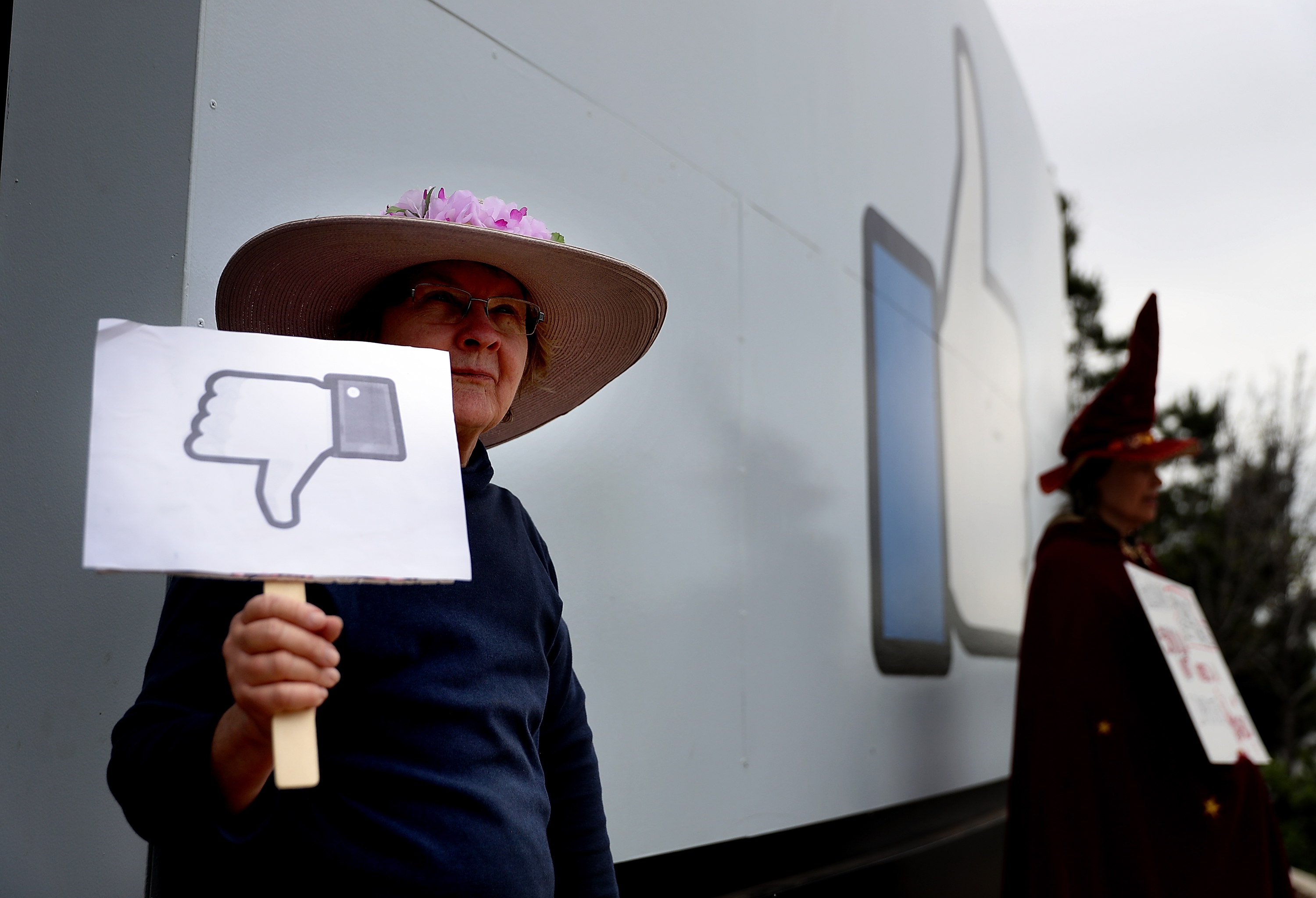 A protester with the group ‘Raging Grannies’ holds a sign during a demonstration outside of Facebook headquarters on April 5, 2018 in Menlo Park, California.&nbsp;