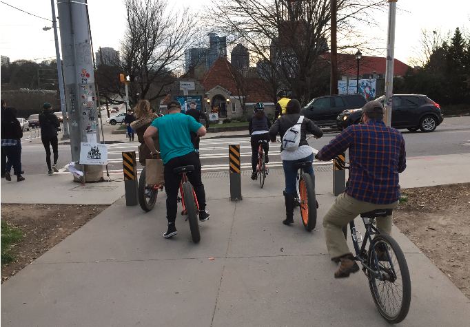 A photo of cyclists waiting for their turn at the intersection of 10th Street and Monroe Drive, a chokepoint for pedestrians.