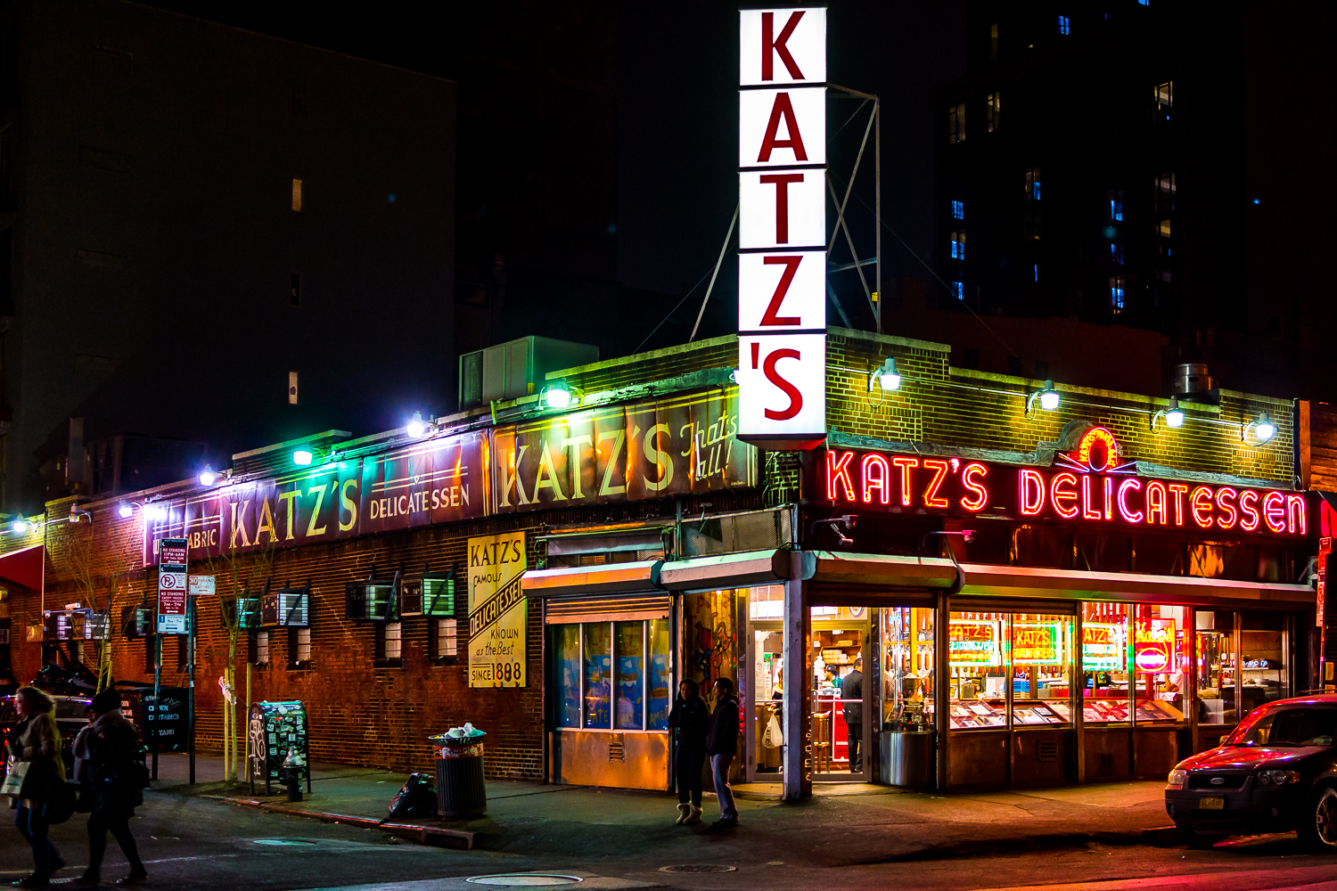 Katz’s in 2015 with glowing neon signs on a corner at midnight.