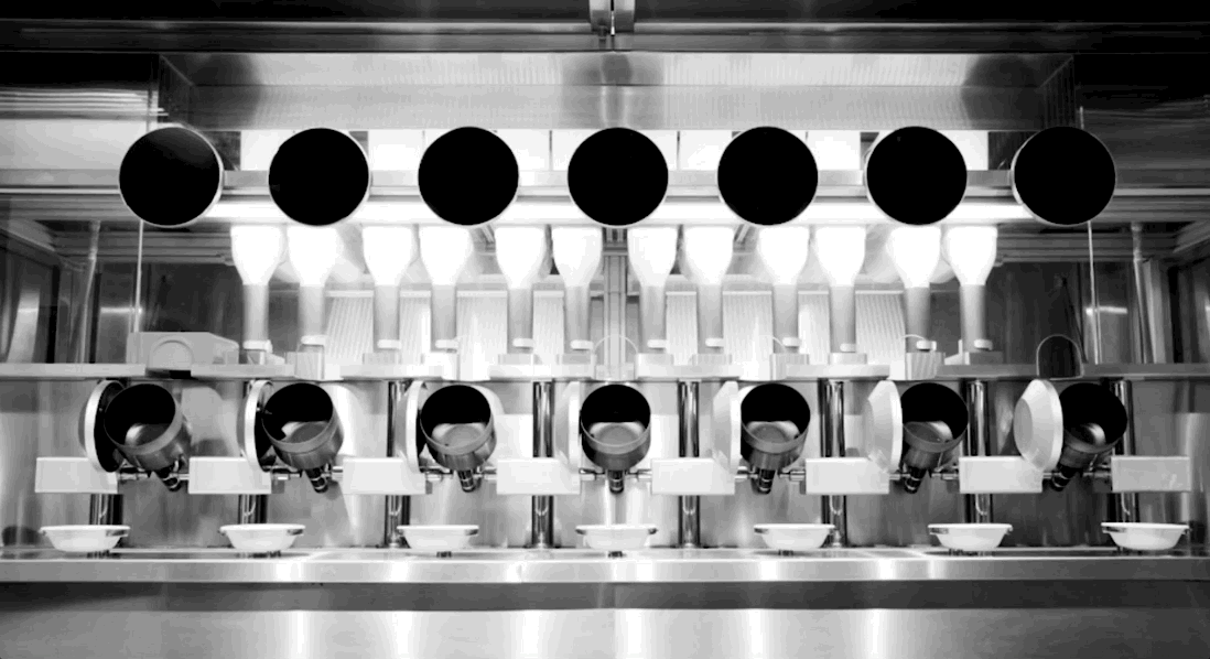 A black-and-white GIF of the Spyce robotic kitchen in action