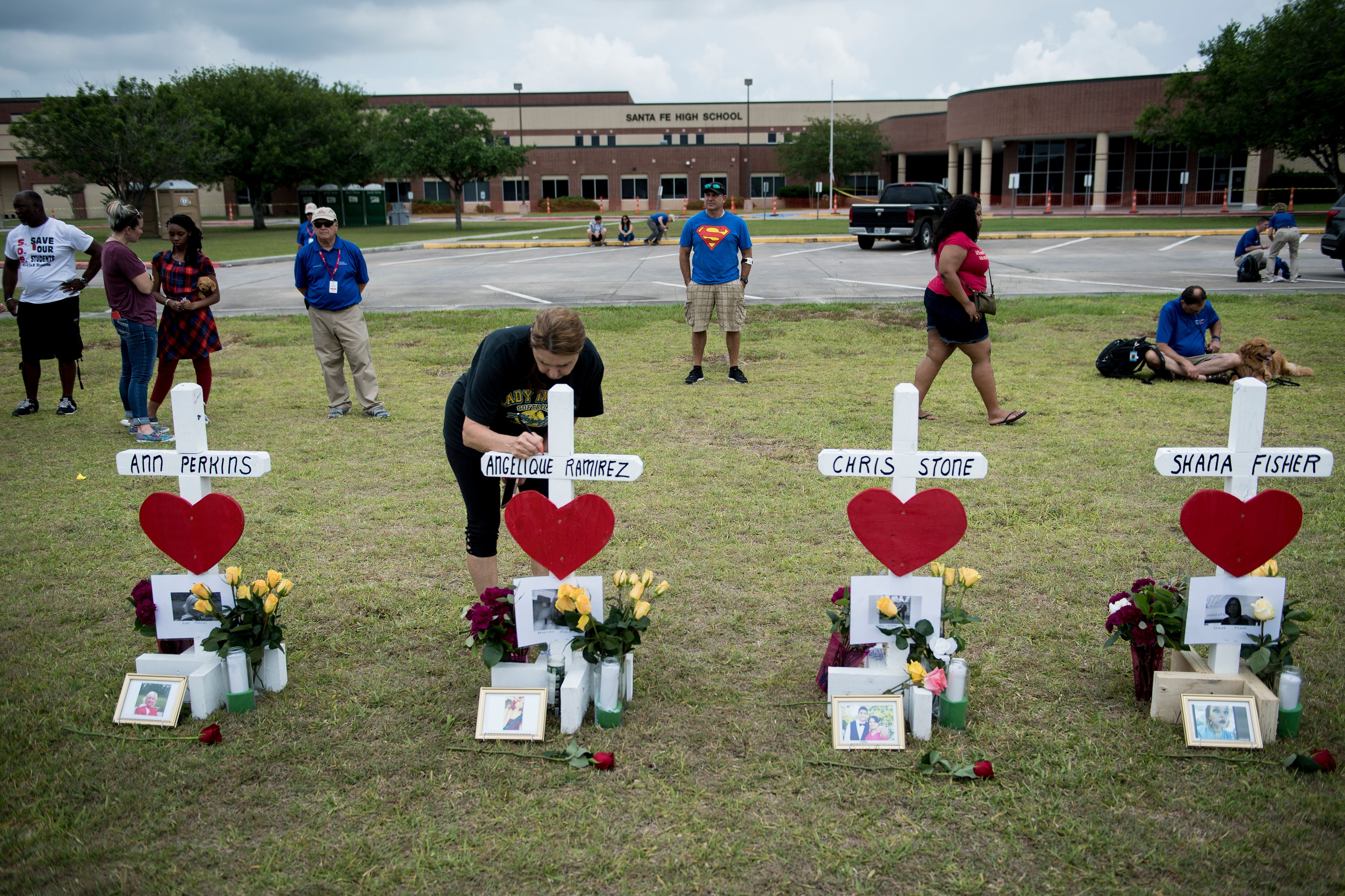 People pay their respects to victims of the Santa Fe High School shooting victims.