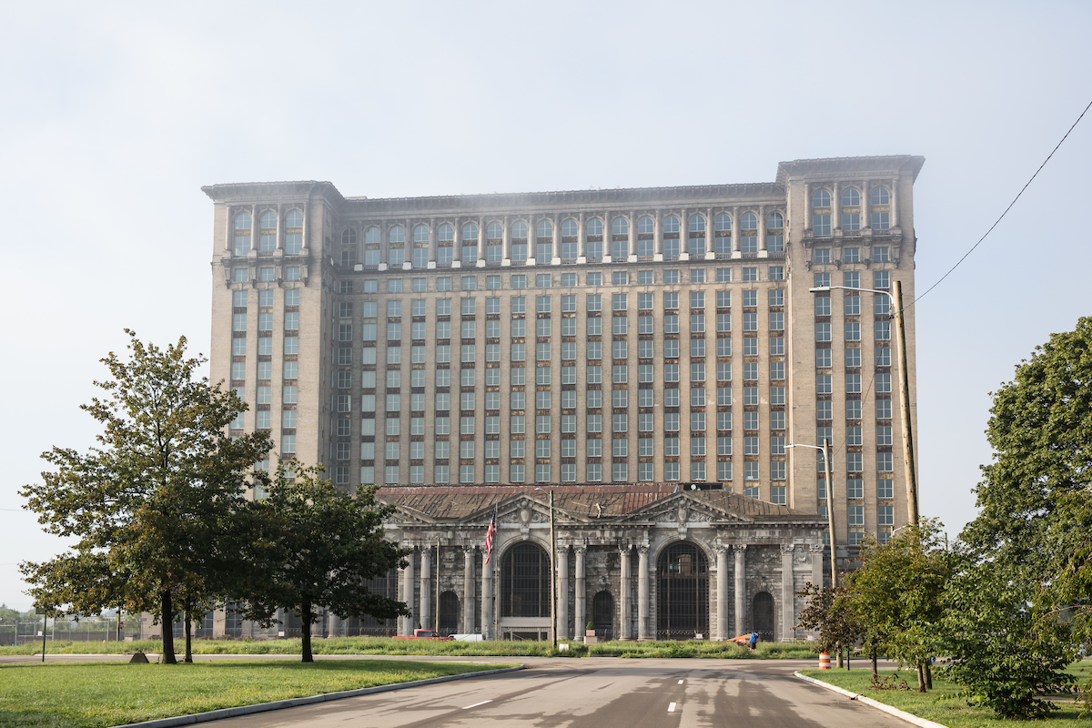 The exterior of Michigan Central Station in Detroit. The facade has multiple windows and columns flanking the entryway and lower level windows.