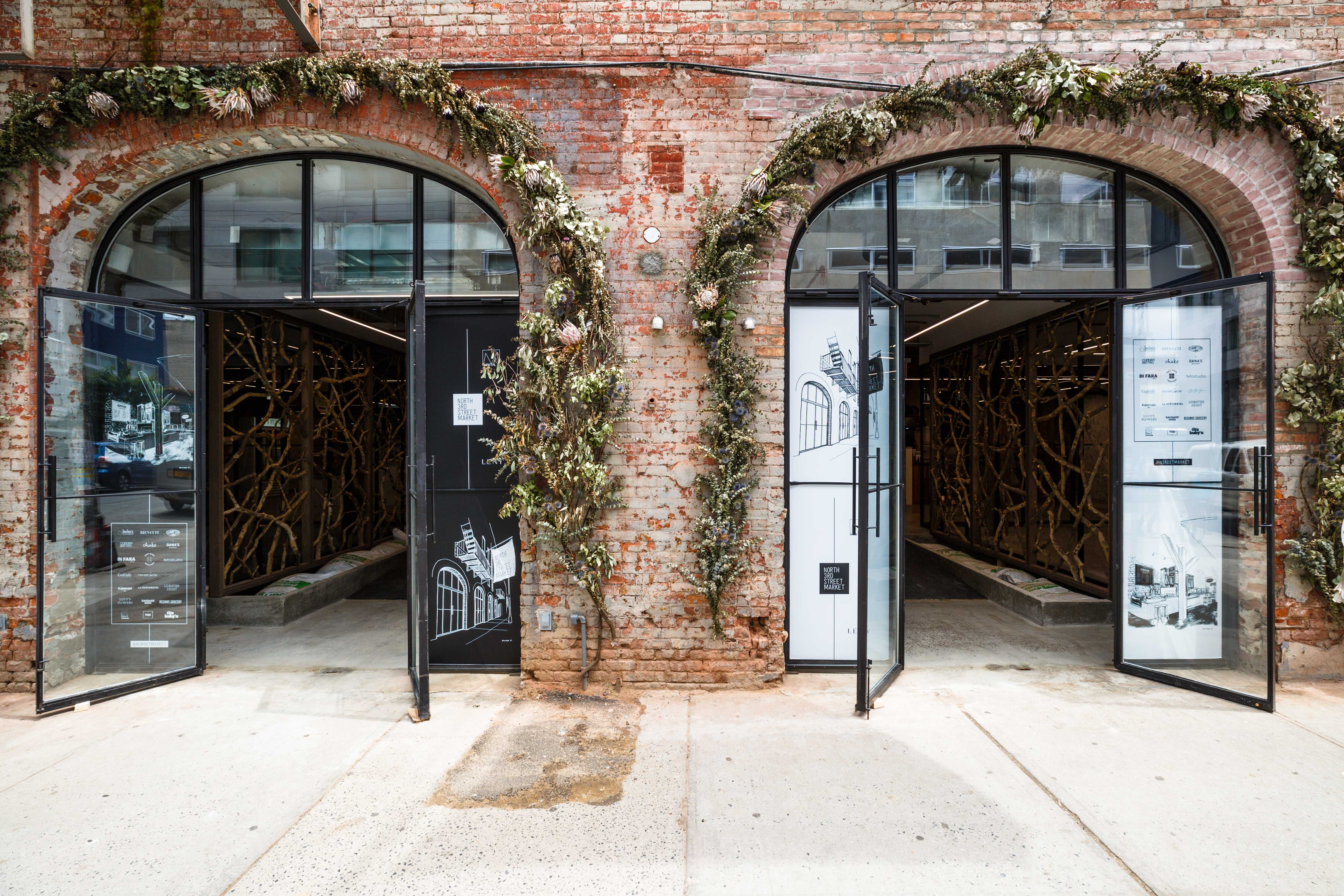 Two sets of doors open into a dimly lit food hall in Williamsburg, Brooklyn.