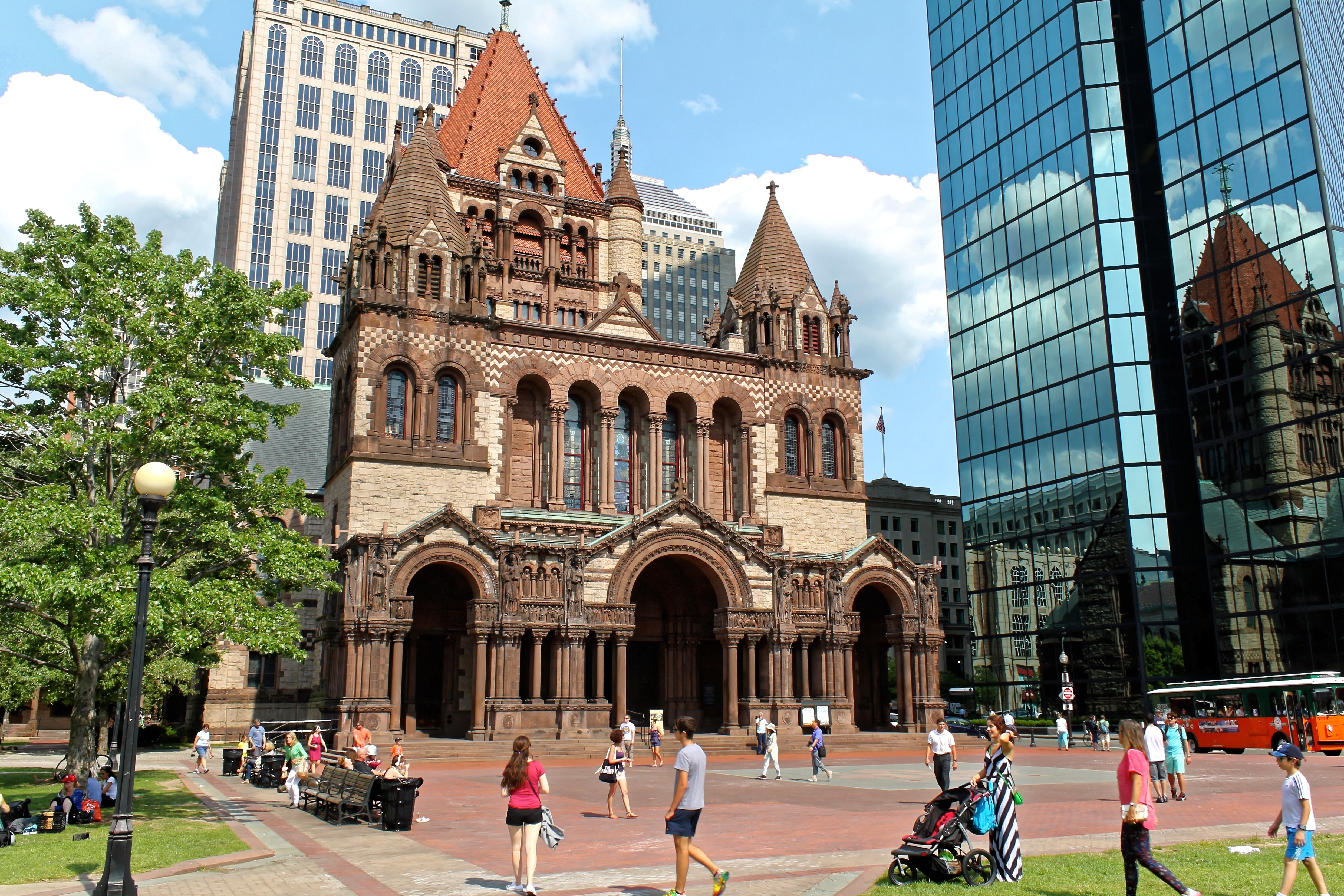 A pedestrian square with a grand church on one side and a modern skyscraper on another.