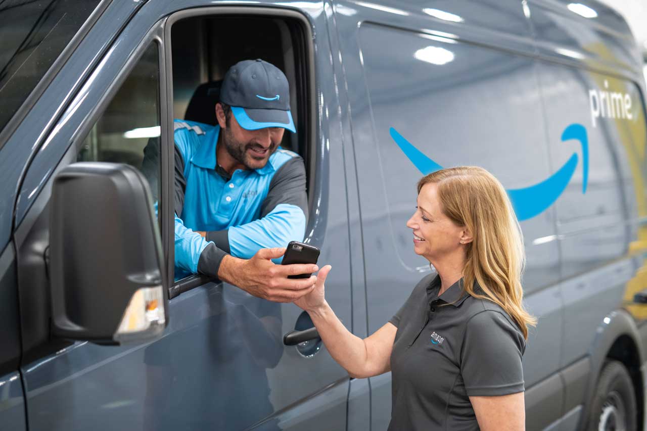 Amazon delivery people chat in front of a new Amazon delivery van