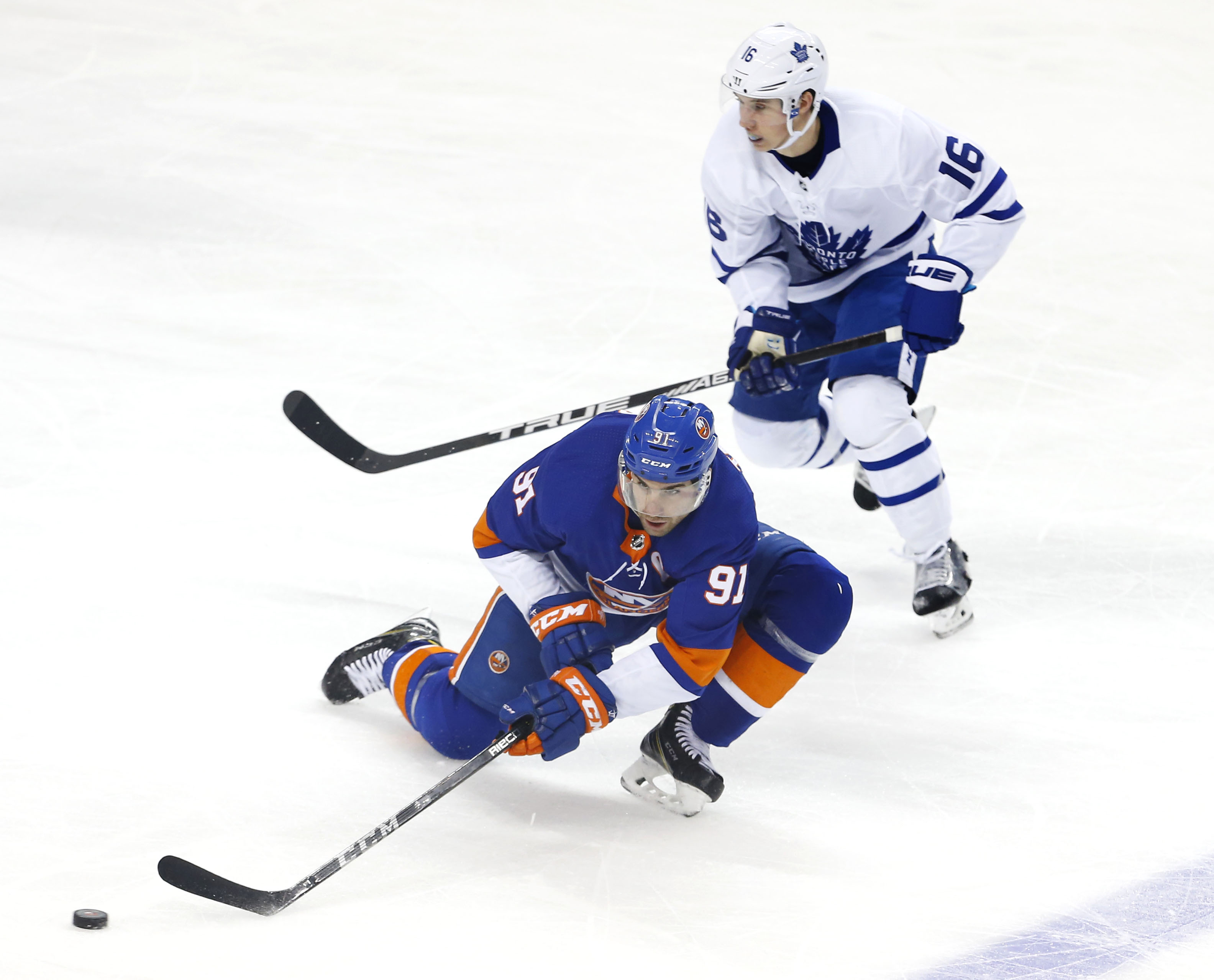 Mar 30, 2018; Brooklyn, NY, USA; New York Islanders center John Tavares (91) passes the puck against Toronto Maple Leafs center Mitchell Marner (16) during the second period at Barclays Center.