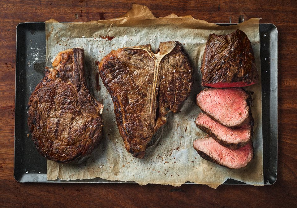 Three cooked T-bone steaks, one sliced.