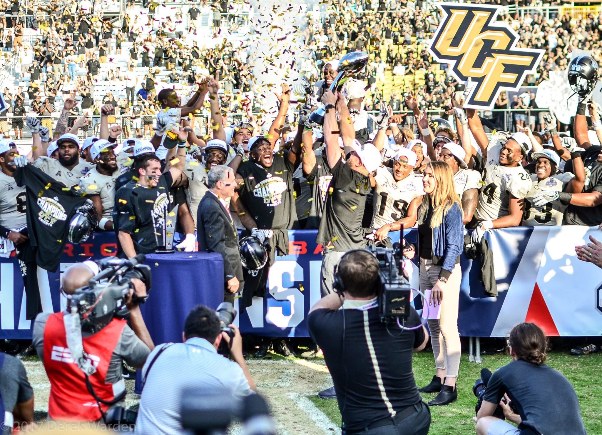 UCF head coach Scott Frost holds up the American Athletic Conference Championship Trophy as his team celebrates winning the title Saturday, December 2, 2017. (Photo: Derek Warden)