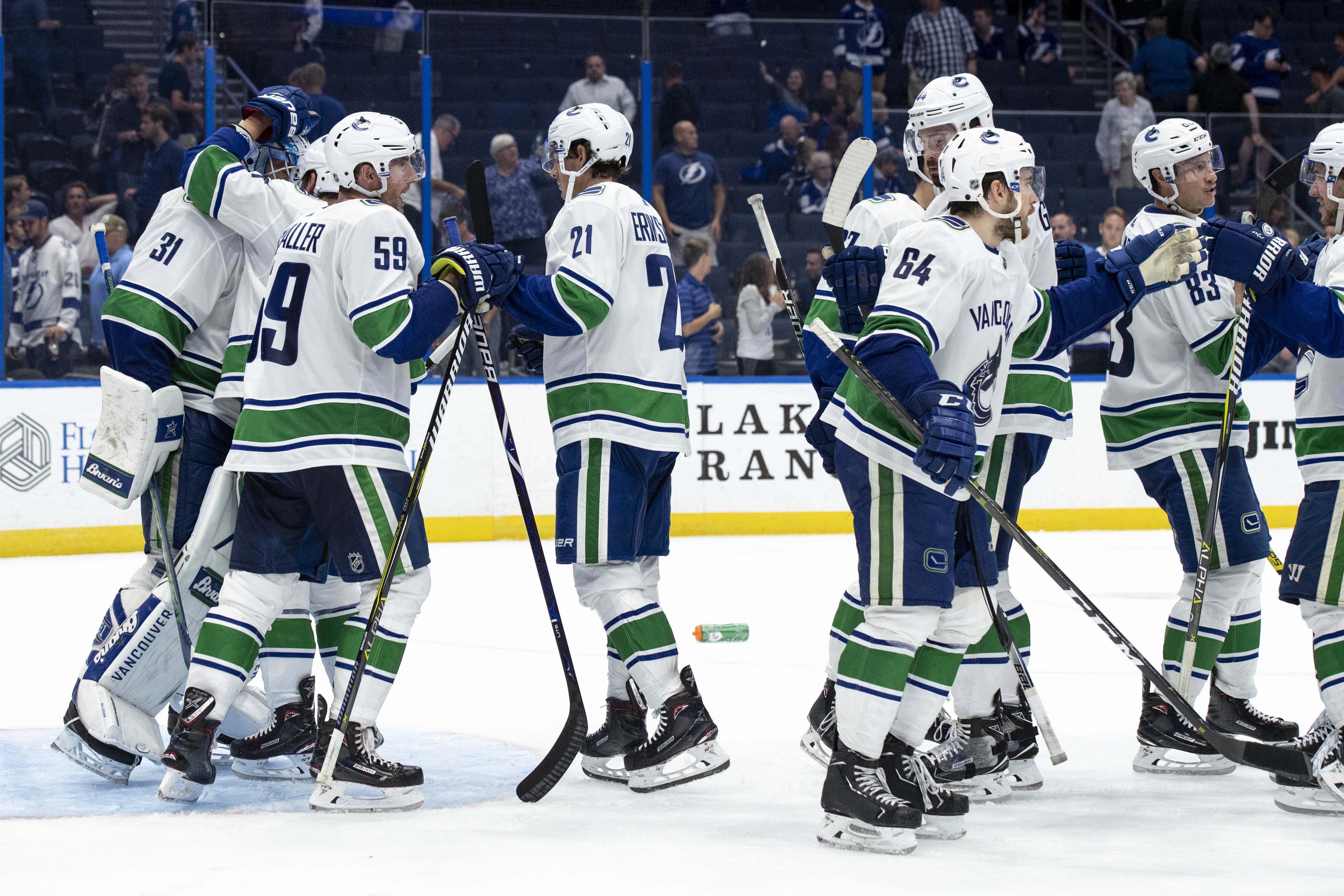 Oct 11, 2018; Tampa, FL, USA; Vancouver Canucks goalie Anders Nilsson (31) is congratulated by his teammates after the game between the Vancouver Canucks and Tampa Bay Lightning at Amalie Arena. Mandatory Credit: Douglas DeFelice