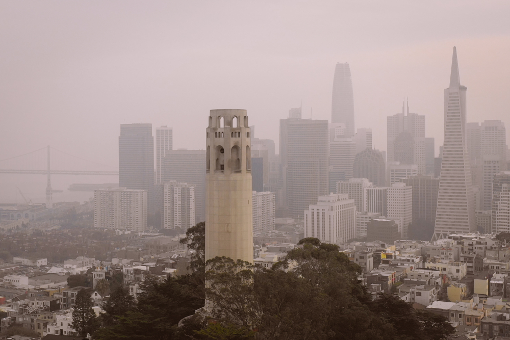 Coit Tower against a smoke-filled SF skyline.