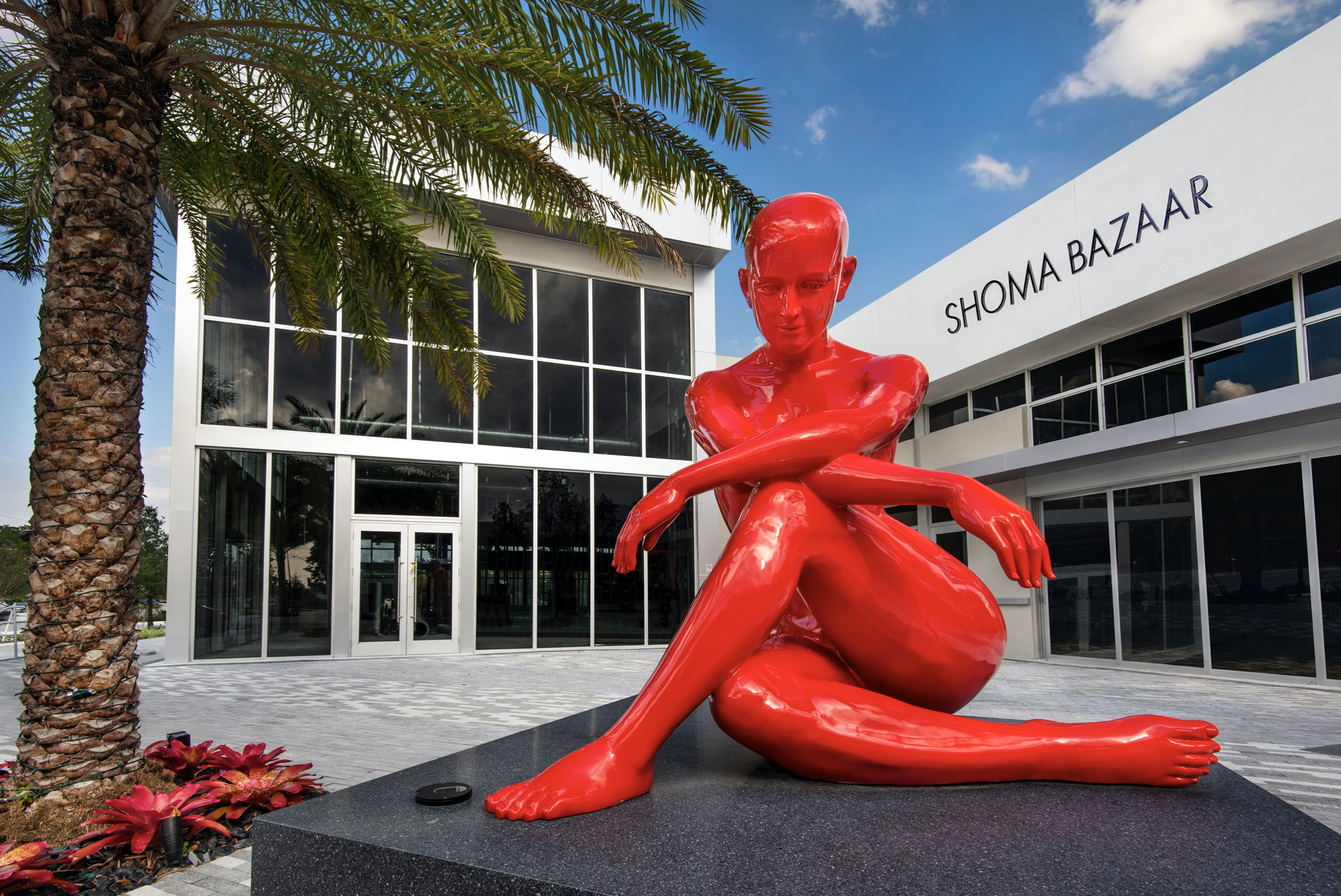 red statue in front of building.