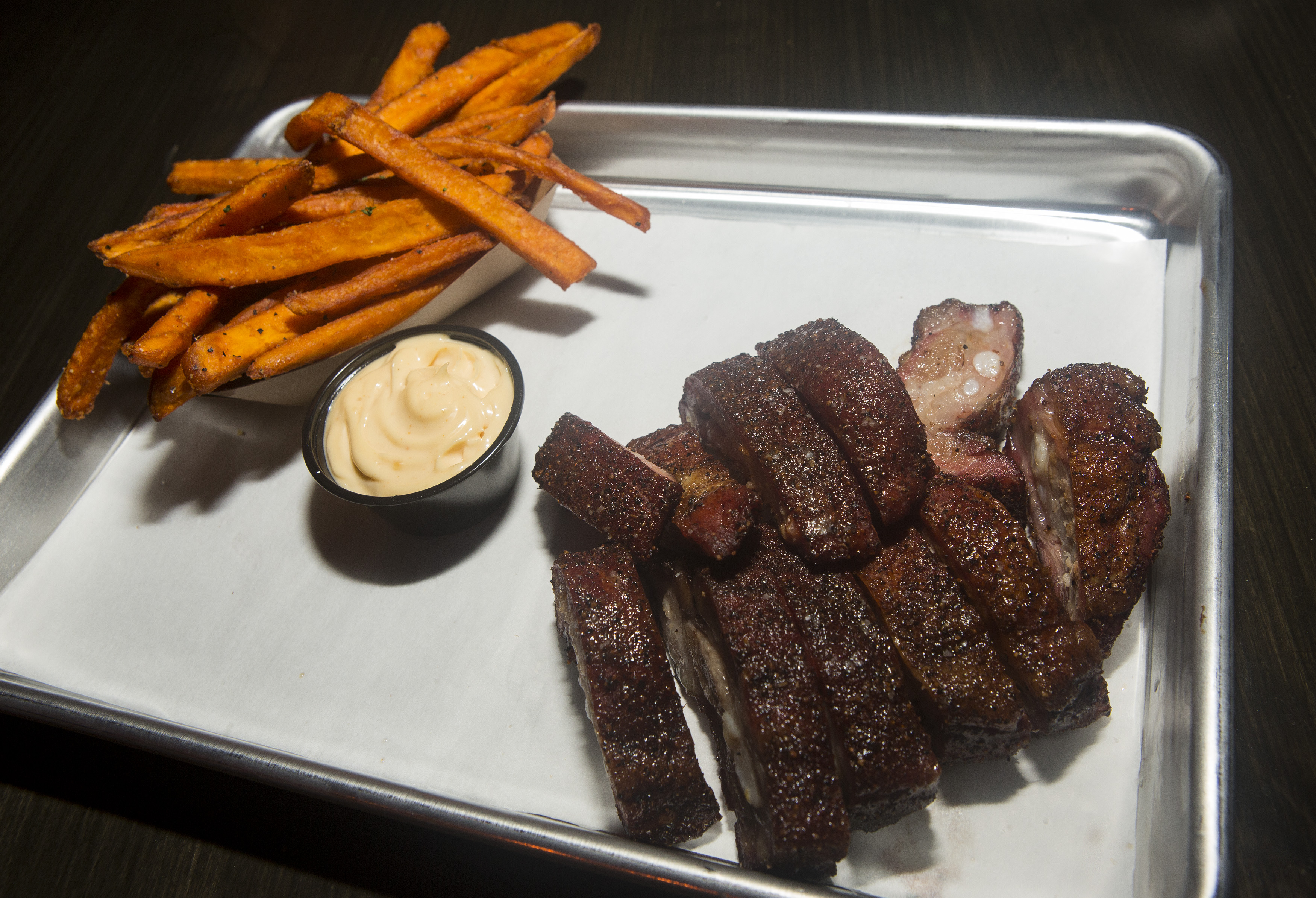 A platter of baby back ribs and sweet potato fries.