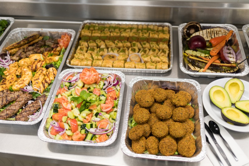 A spread of Mediterranean food from Falafel King in Downtown Boston, which includes salad, falafel, and grilled vegetables. 