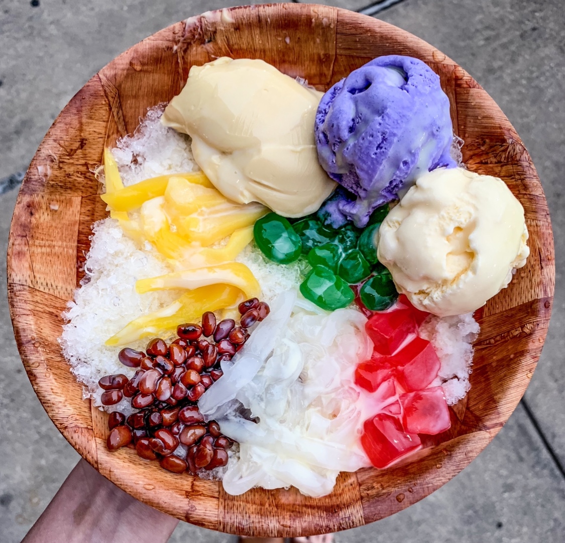 a wooden bowl filled with halo halo desert
