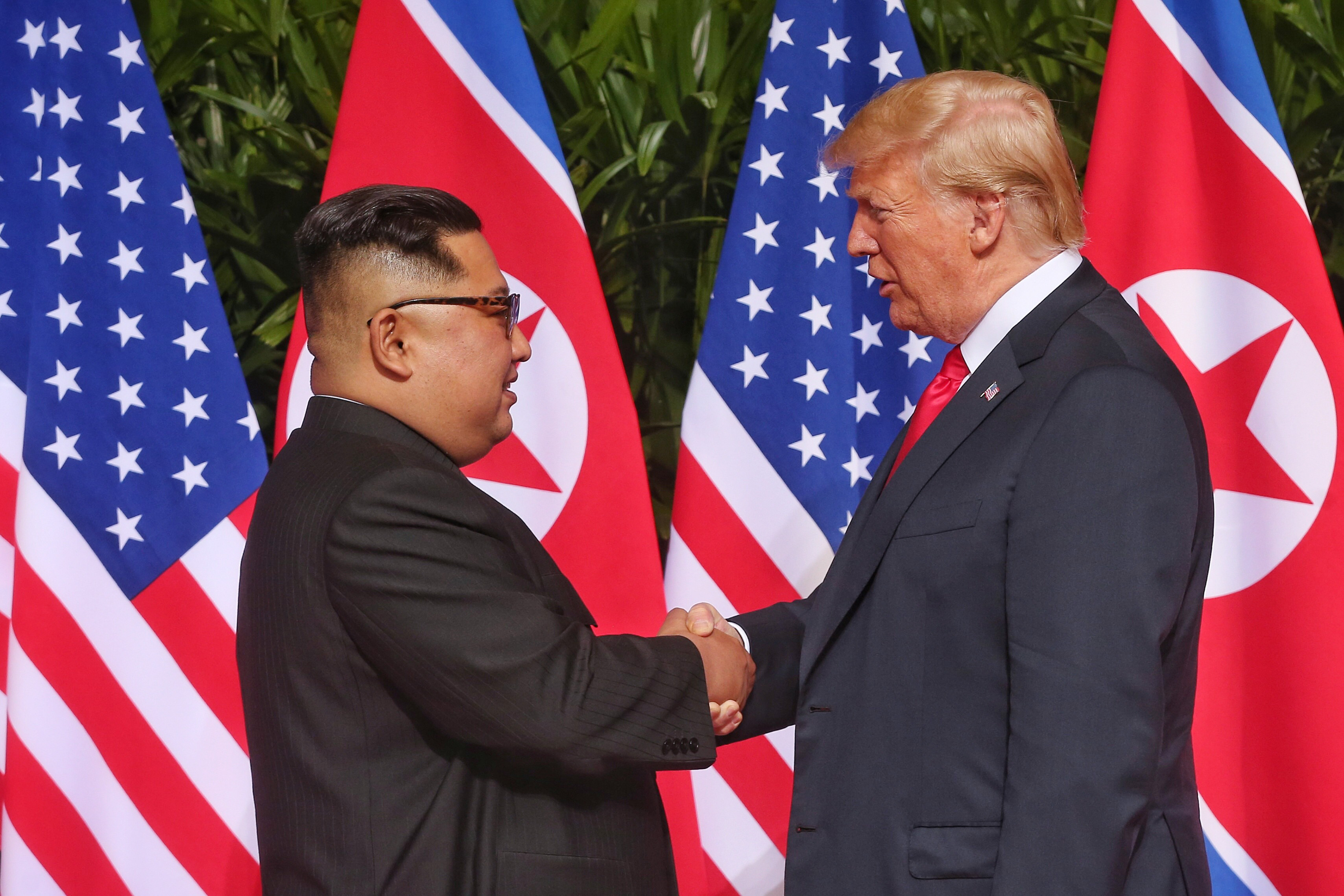 North Korean leader Kim Jong-un shakes hands with President Donald Trump during their historic summit on June 12, 2018 in Singapore.
