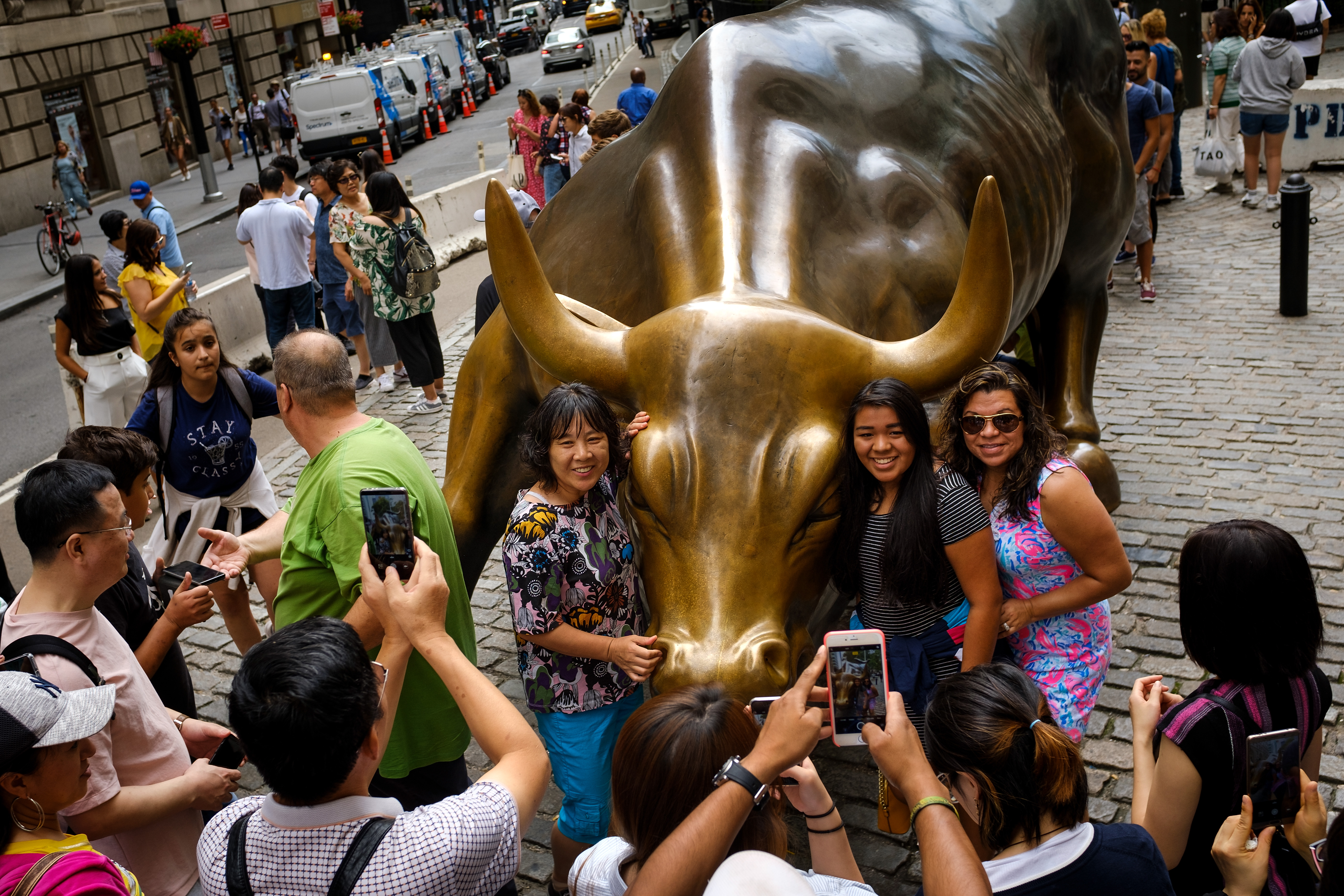Tourists pose with the Wall Street bull statue in the Financial District.