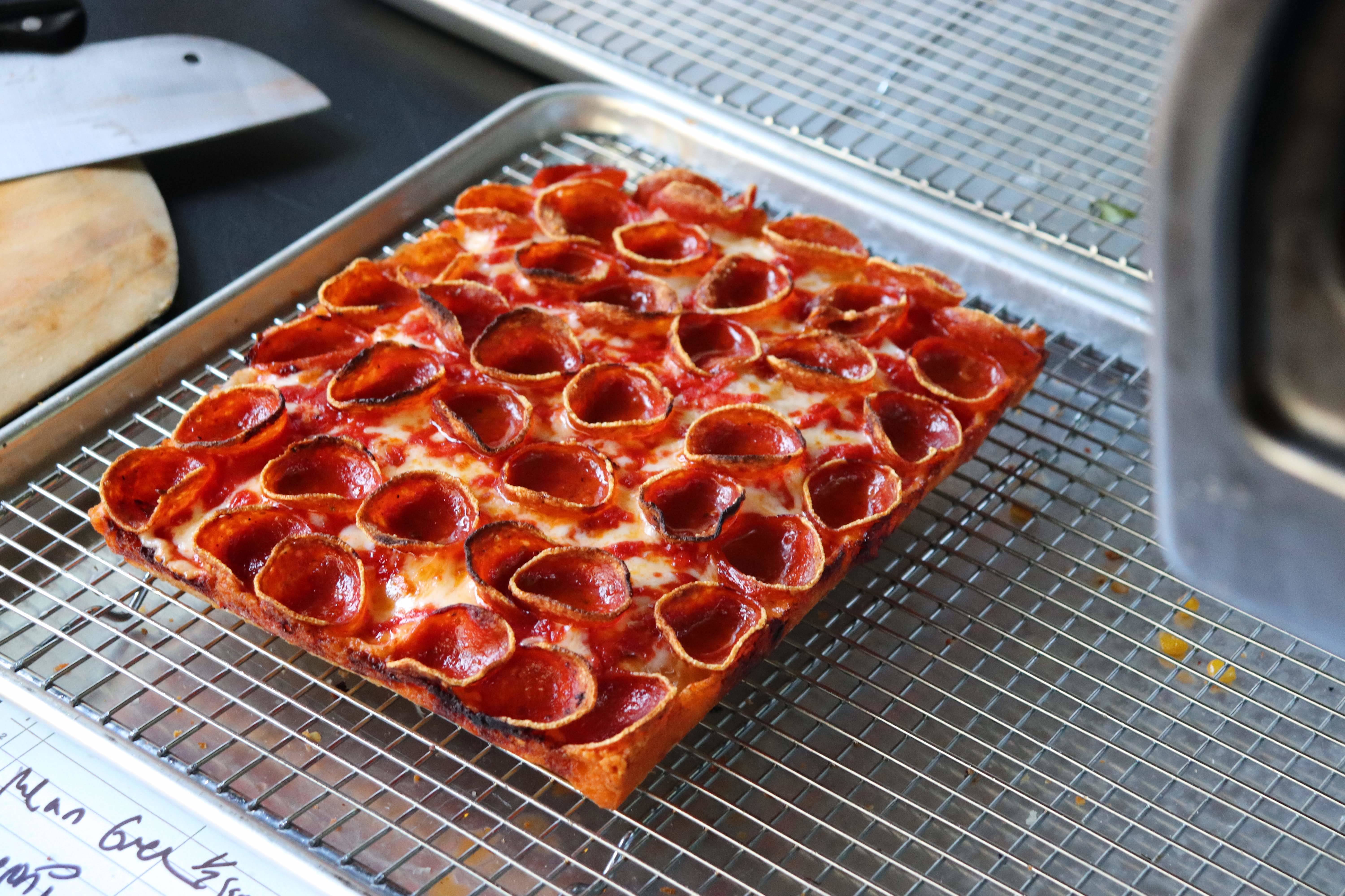 A slab of Detroit-style square pizza with pepperoni cups