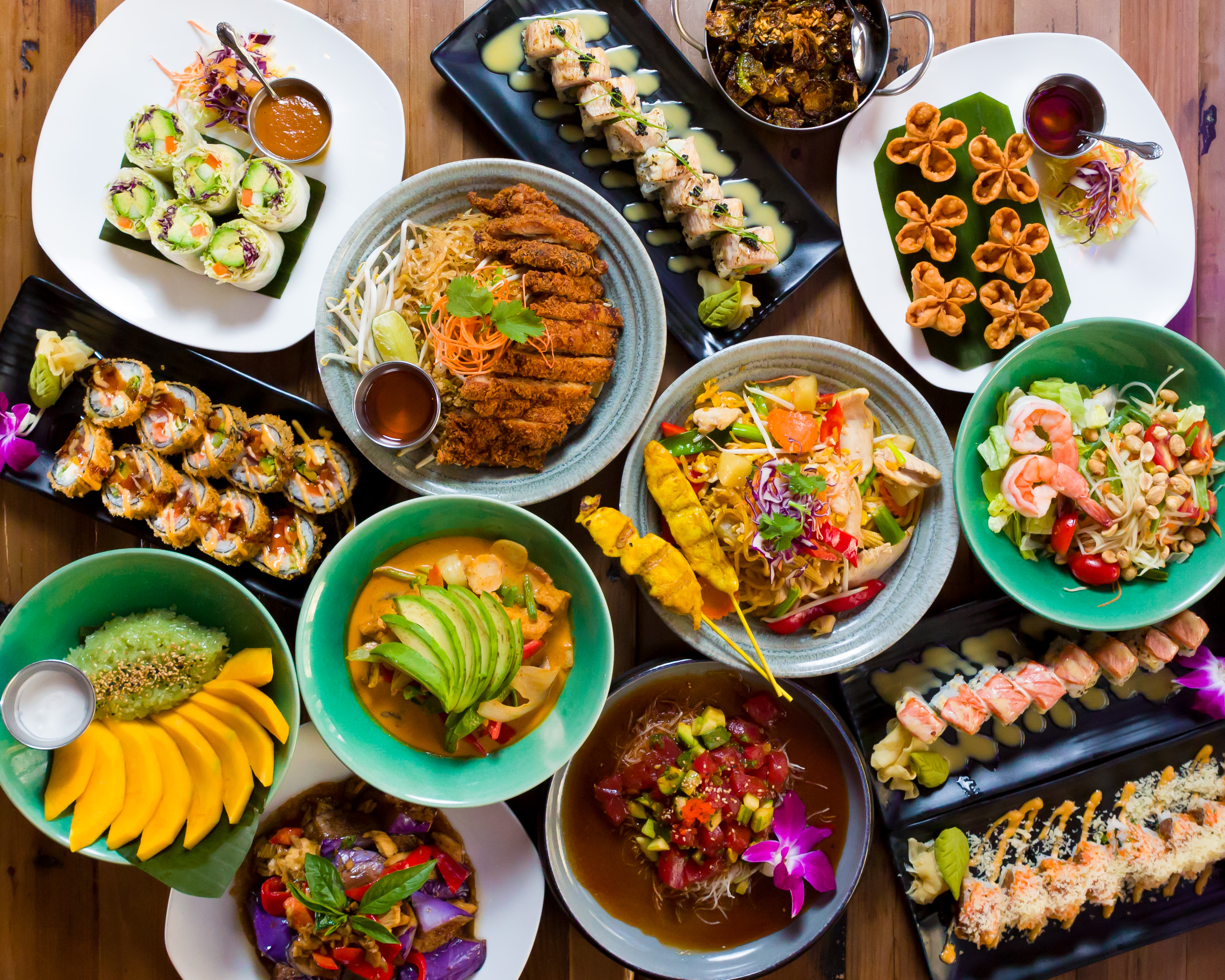 A spread of food from a Thai and Japanese restaurant, viewed from overhead