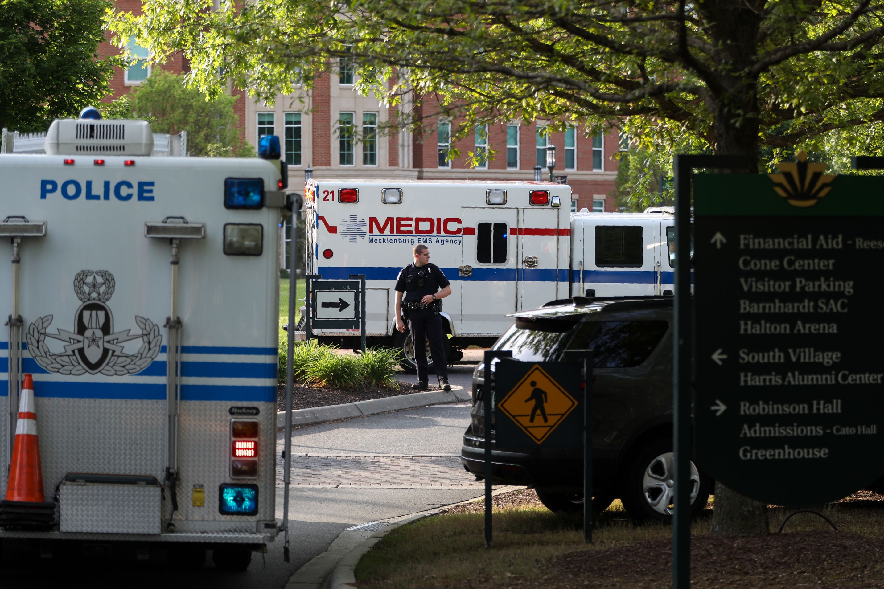 A police officer guides traffic as students and faculty file out of buildings during a lockdown after a shooting on the campus of the University of North Carolina at Charlotte on April 30, 2019.