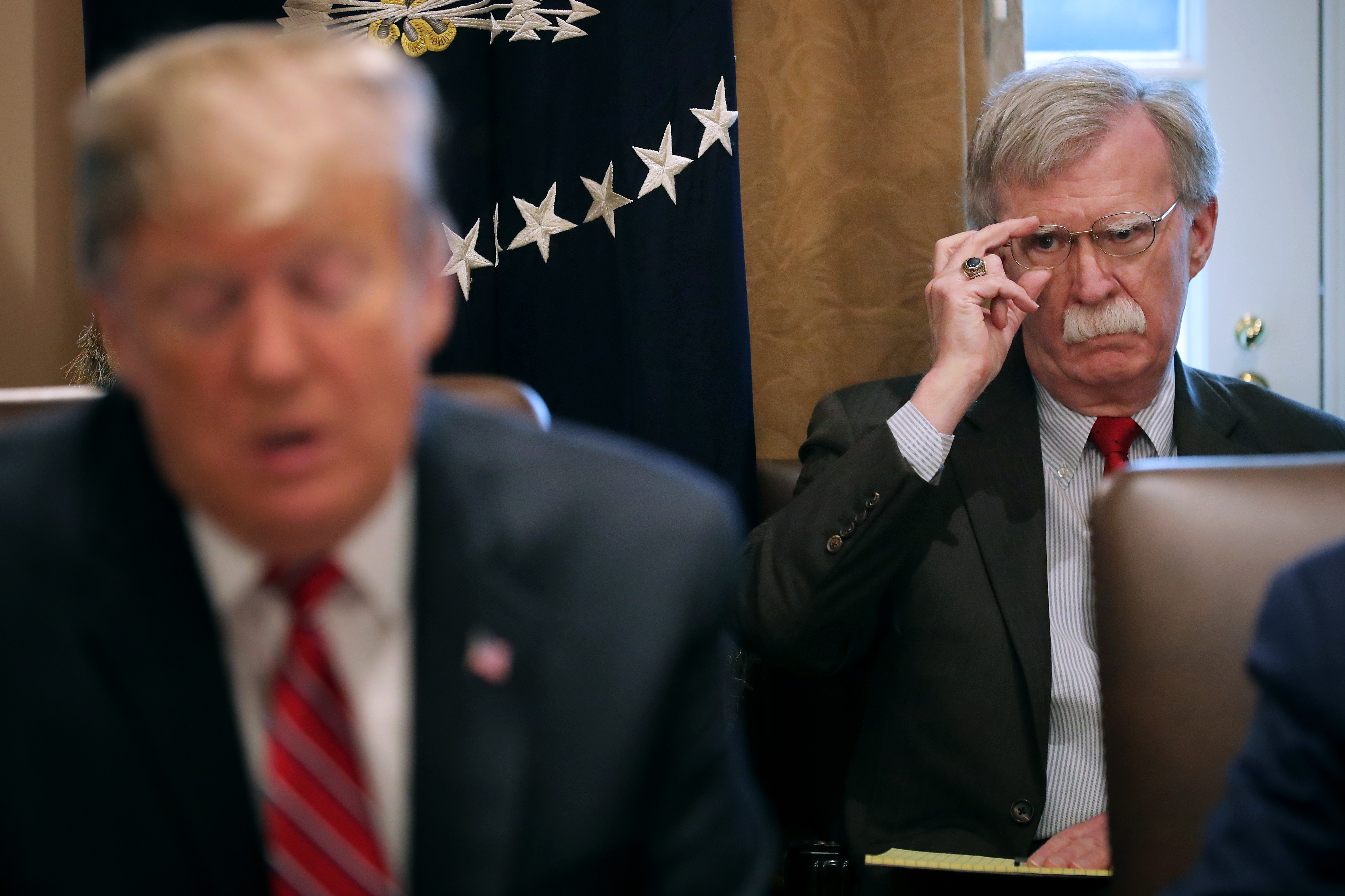 National Security Adviser John Bolton listens to President Donald Trump talk to reporters during a meeting at the White House on February 12, 2019.&nbsp;