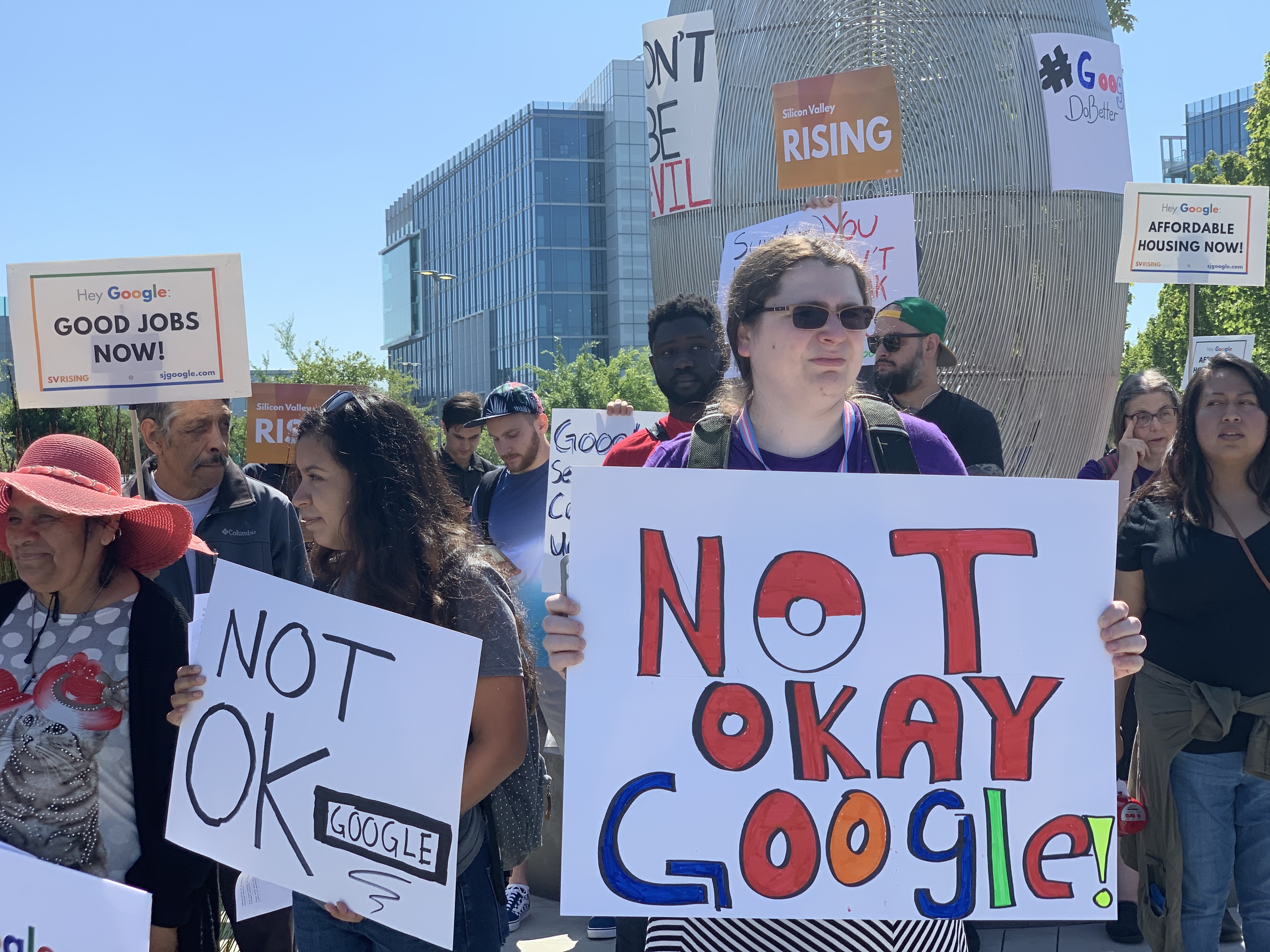 Google employees protesting outside the company’s shareholder meeting hold signs reading, “Not OK, Google.”