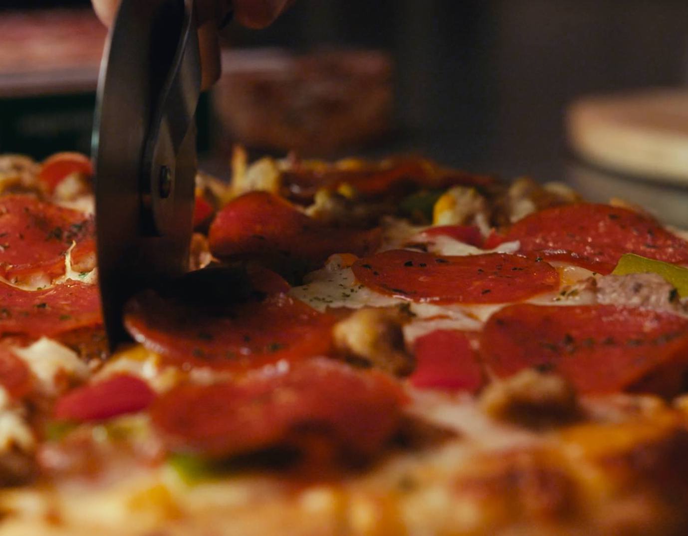 close up of a pizza being sliced