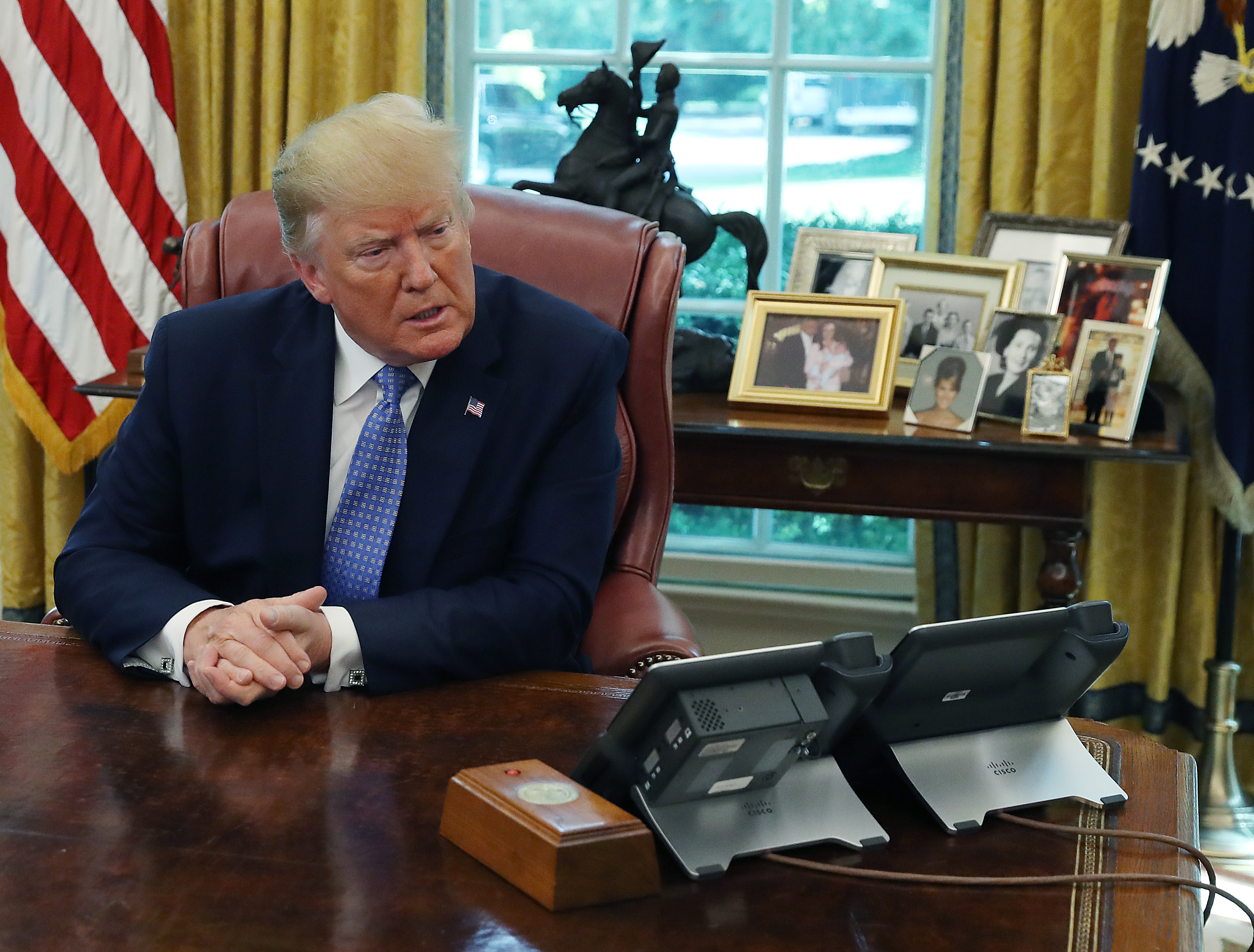 President Donald Trump sitting at his desk in the Oval Office.