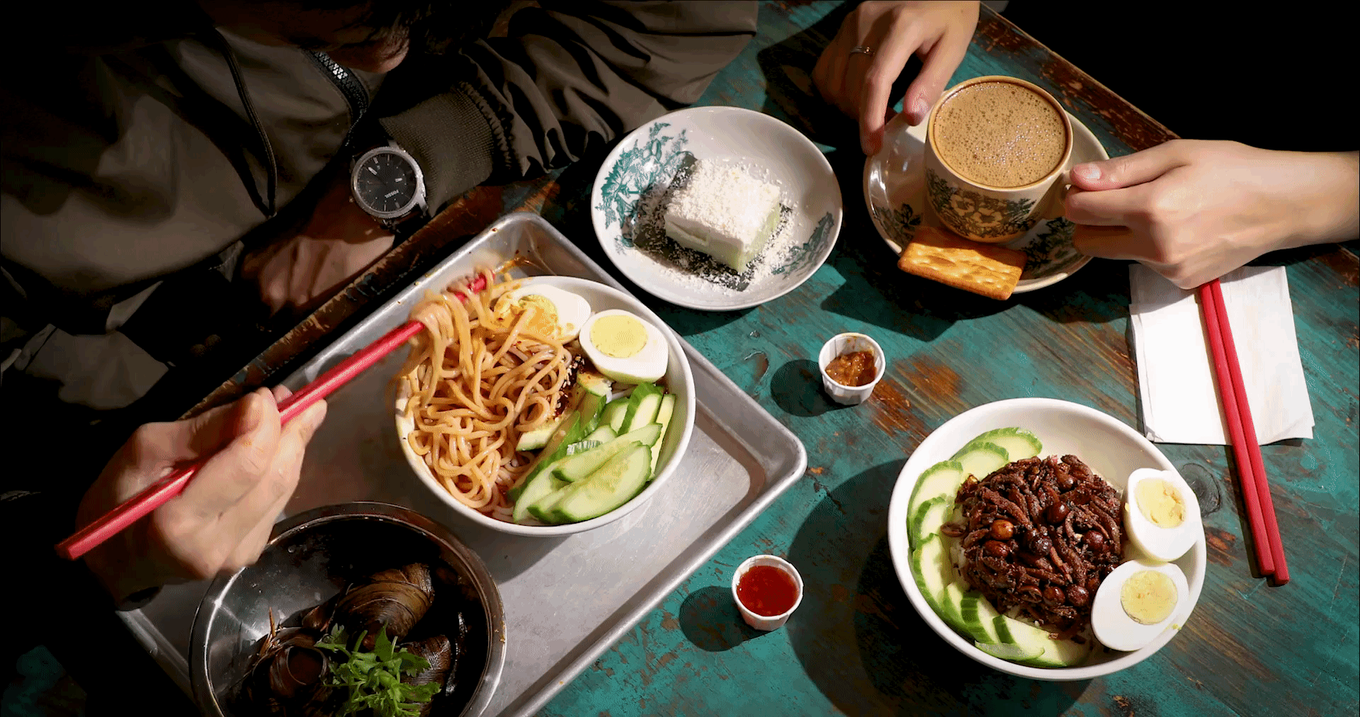 A moving image of noodles being picked up with chopsticks at Kopitiam in New York City