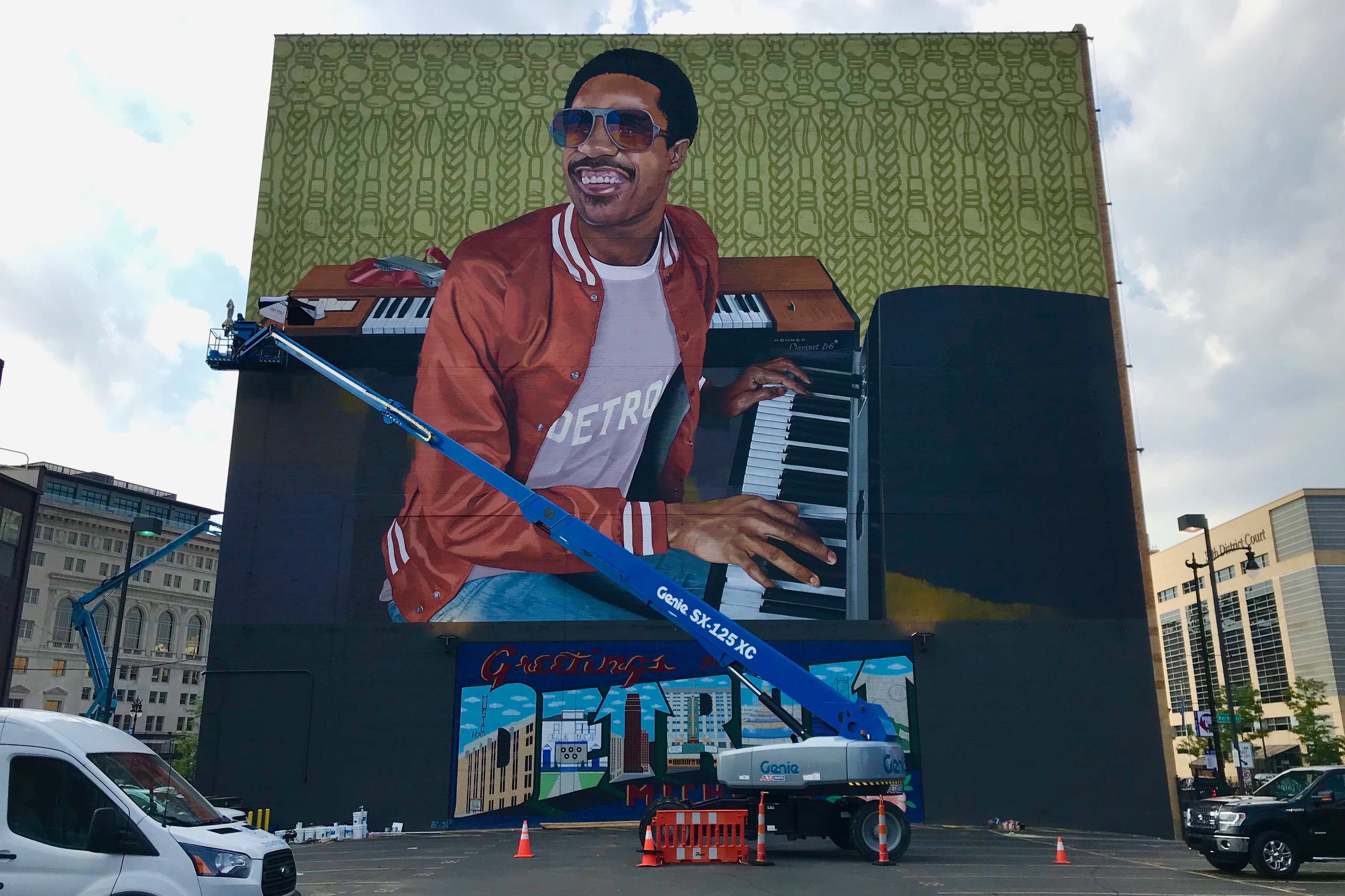 The side of a building. There is a mural depicting Stevie Wonder on the side of the building.