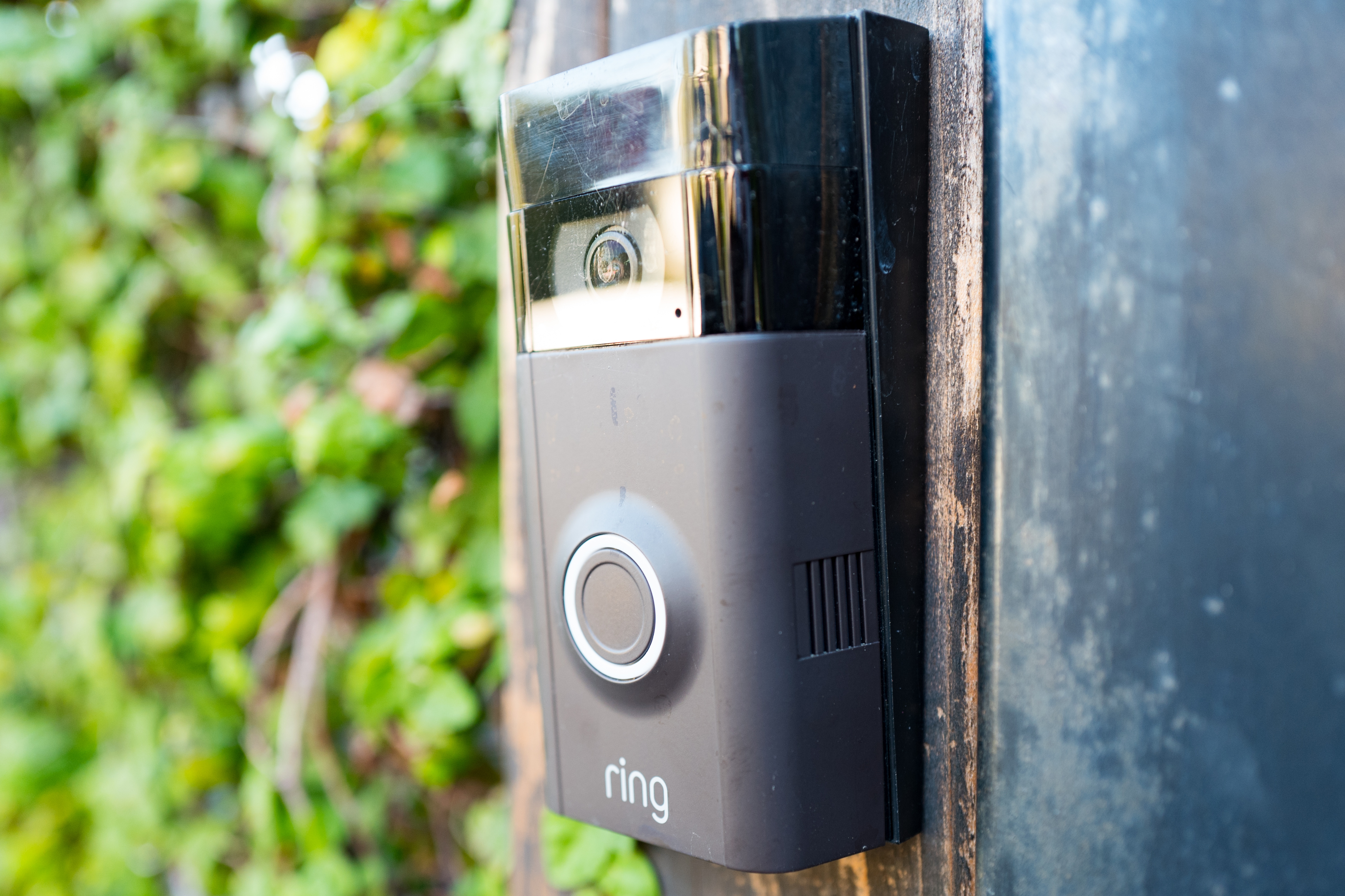 A Ring doorbell on the wall of a house’s front porch.