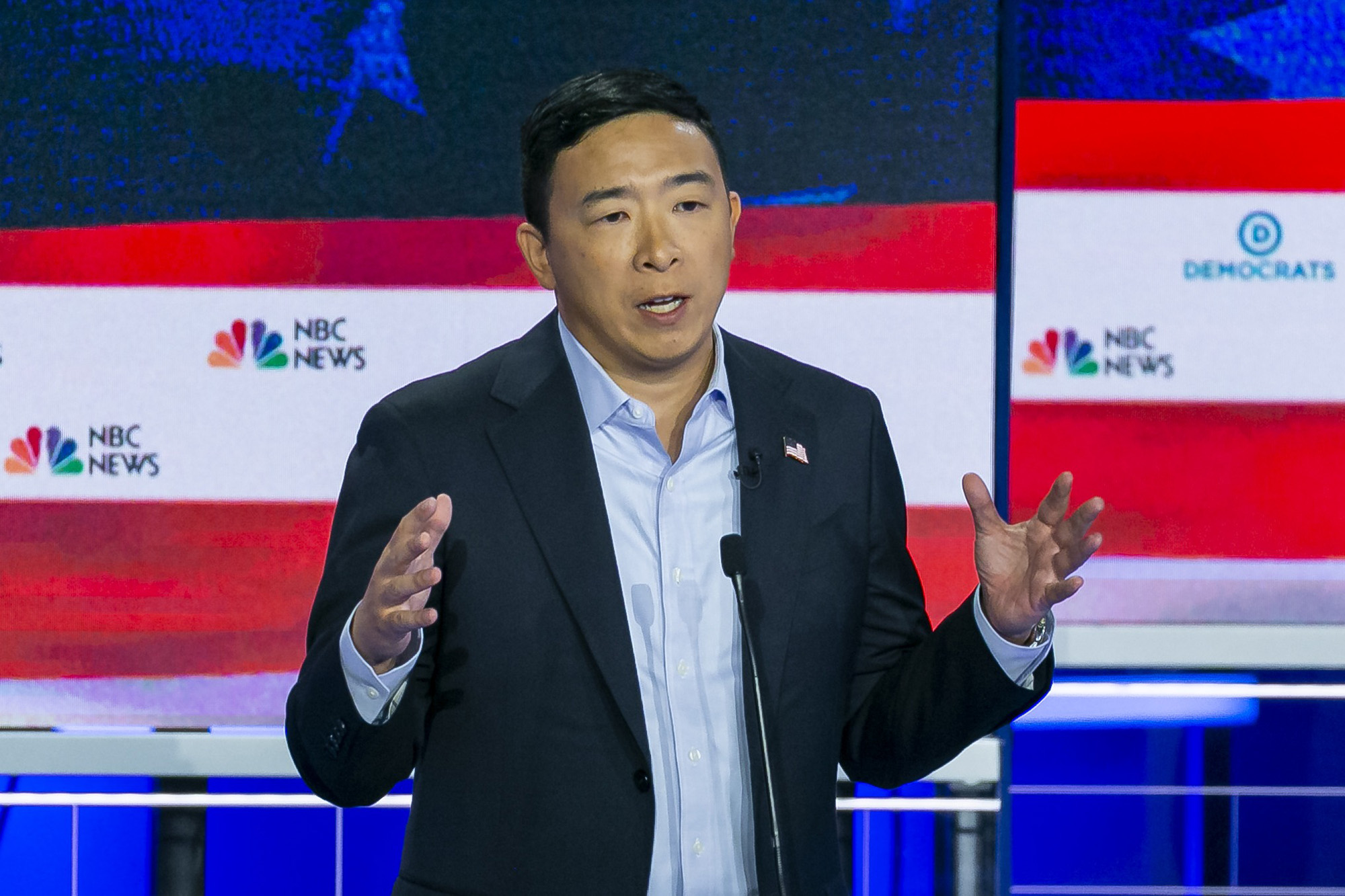 Presidential candidate Andrew Yang holds his hands out while onstage at the first Democratic debate.
