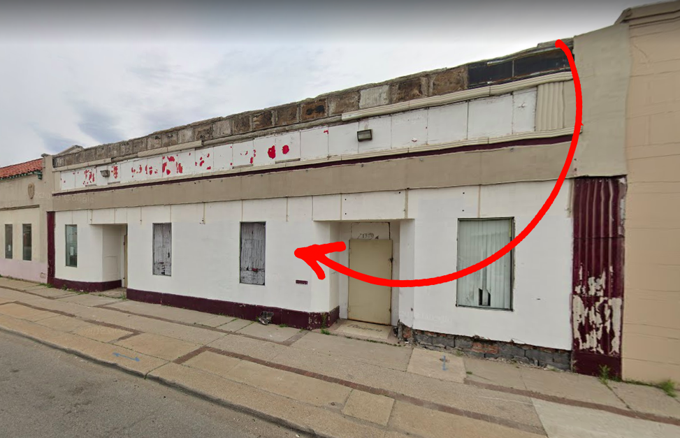 A red arrow pointing to the left at a white and red storefront on McNichols. 