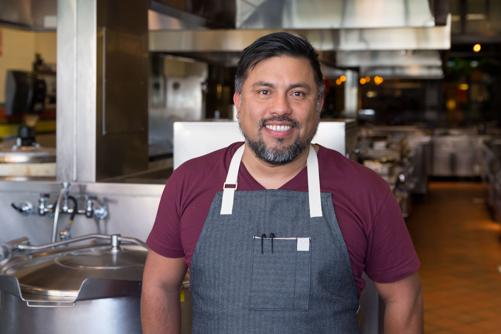 Ricardo Zarate standing in a restaurant with an apron on.