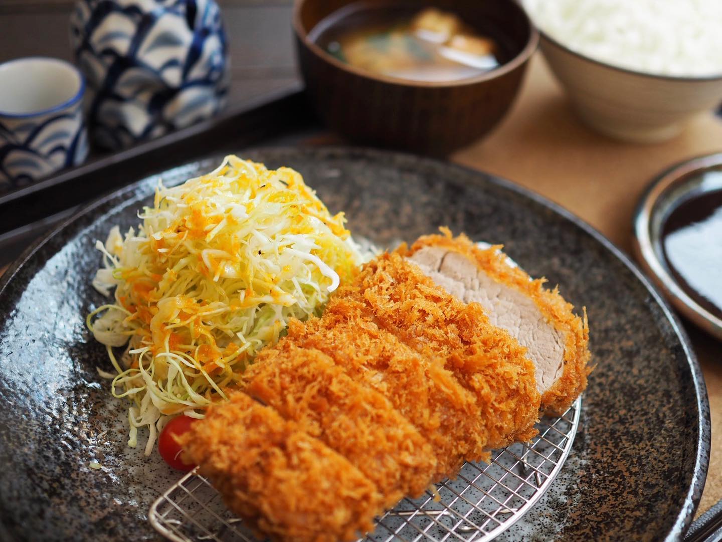 Tonkatsu cutlet next to mound of shredded cabbage.