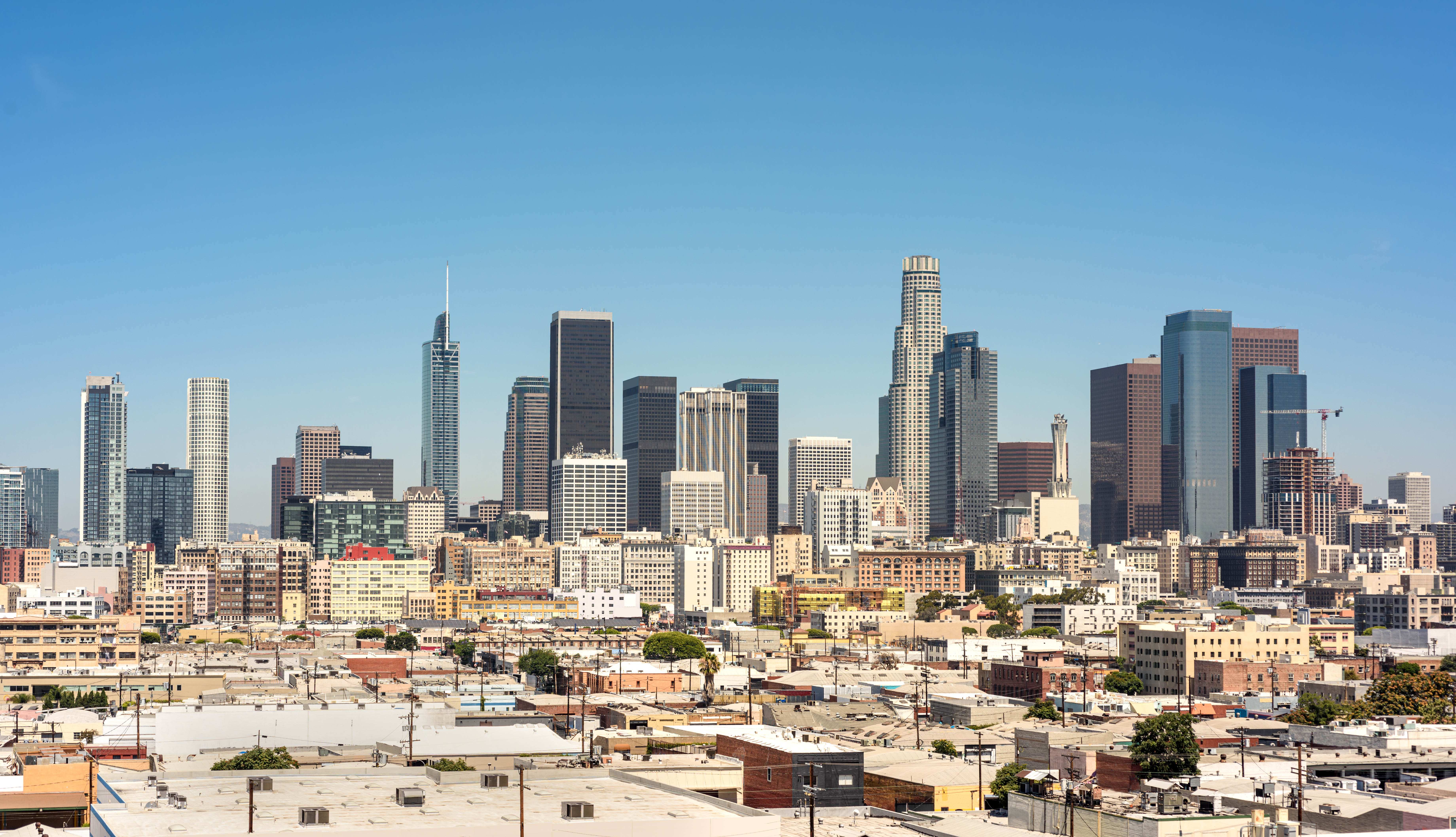 The Los Angeles skyline against a blue sky.
