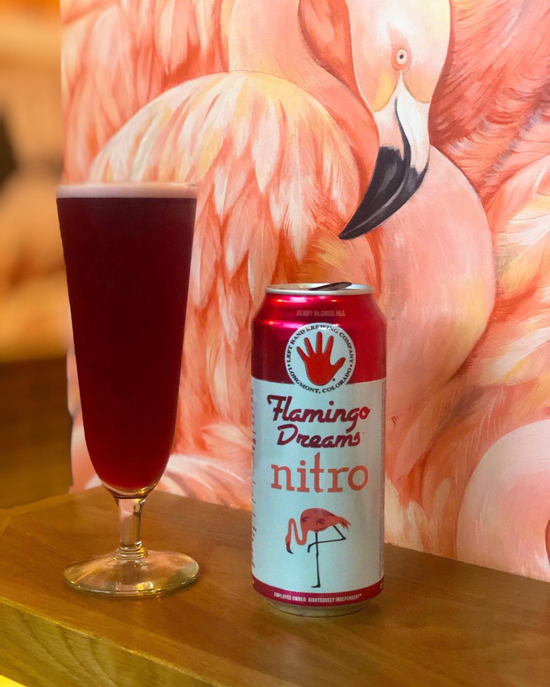 A Flamingo Dreams beer can sits in front of flamingo wallpaper
