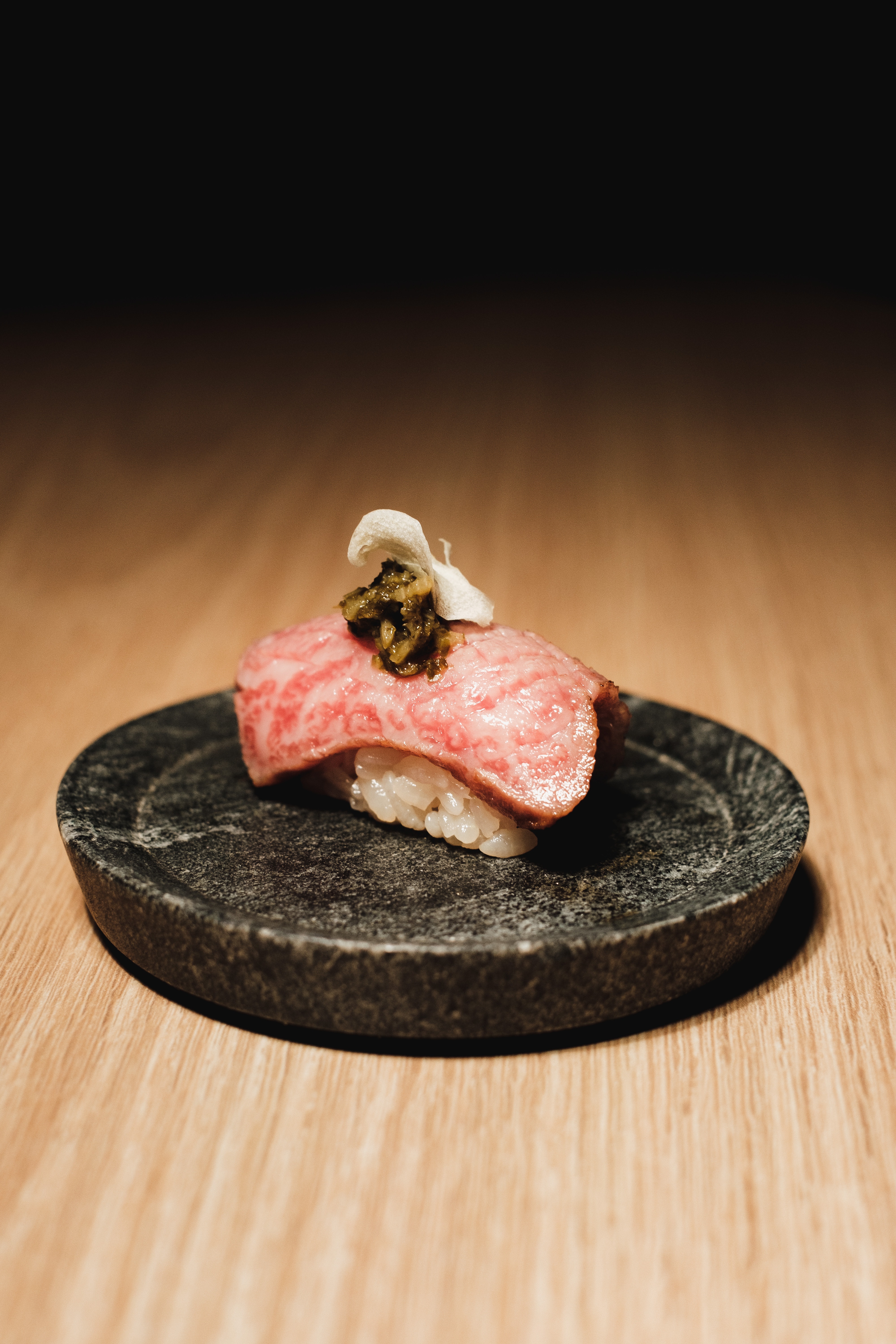 steak nigiri on a black stone.