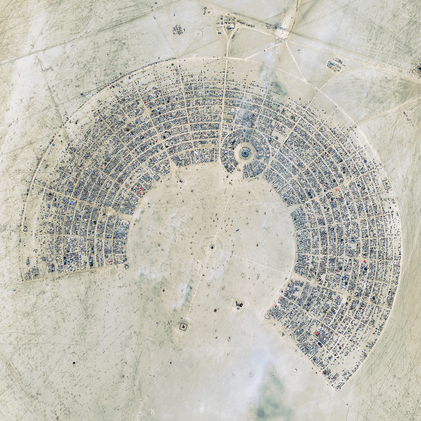A satellite image of the Burning Man festival in Nevada, which is organized as concentric arcs with avenues emanating from the center.