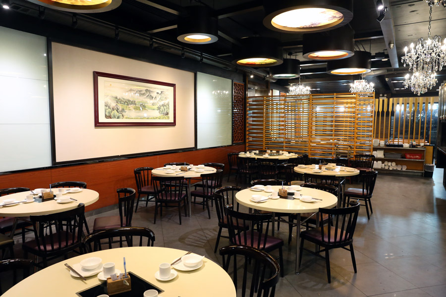 Six circular Chinese dim sum tables sit in a dining room.