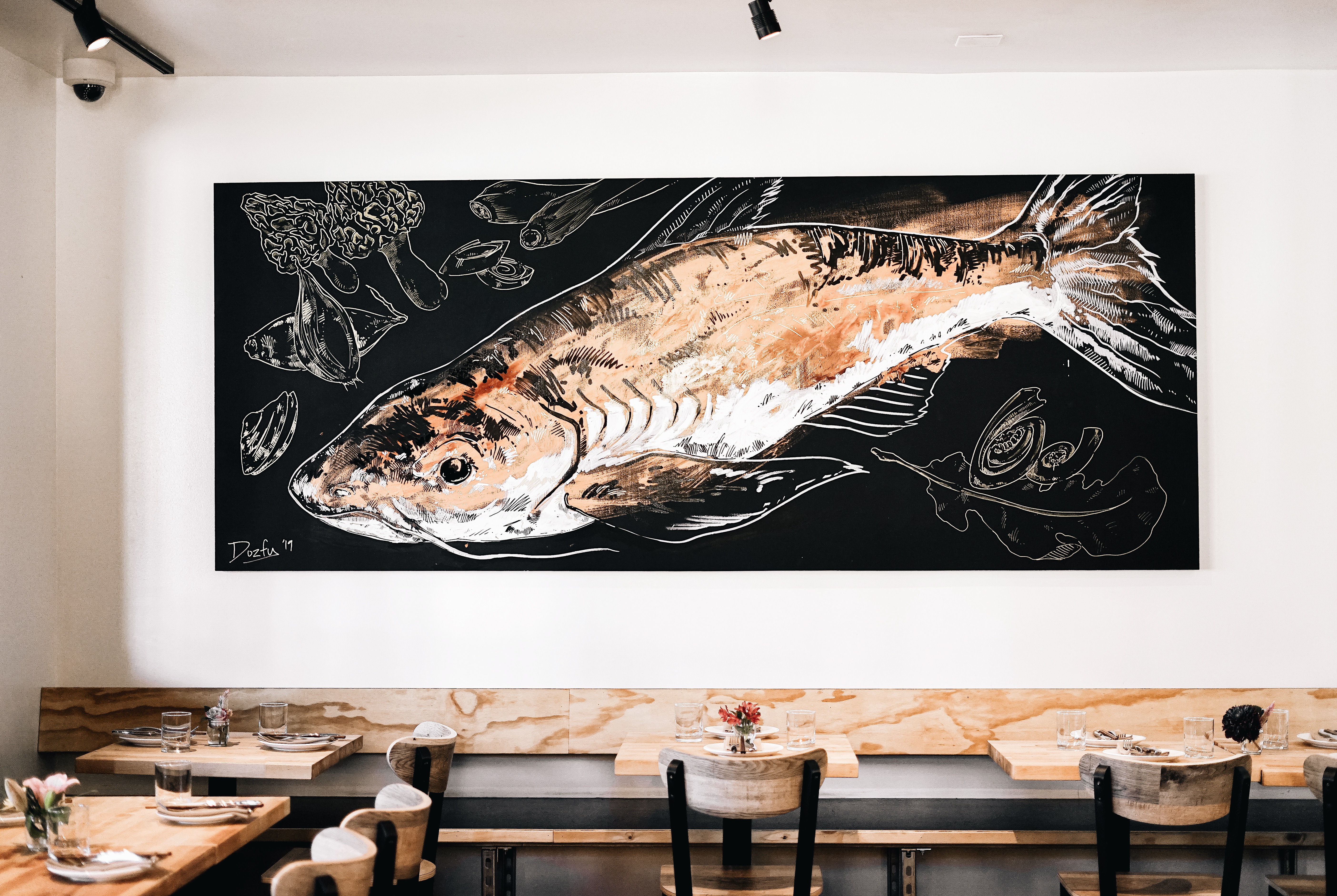 A view of a catfish mural in a light-filled dining room at the restaurant Ba Sa.