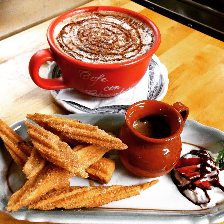red cup with hot chocolate and plate of churros