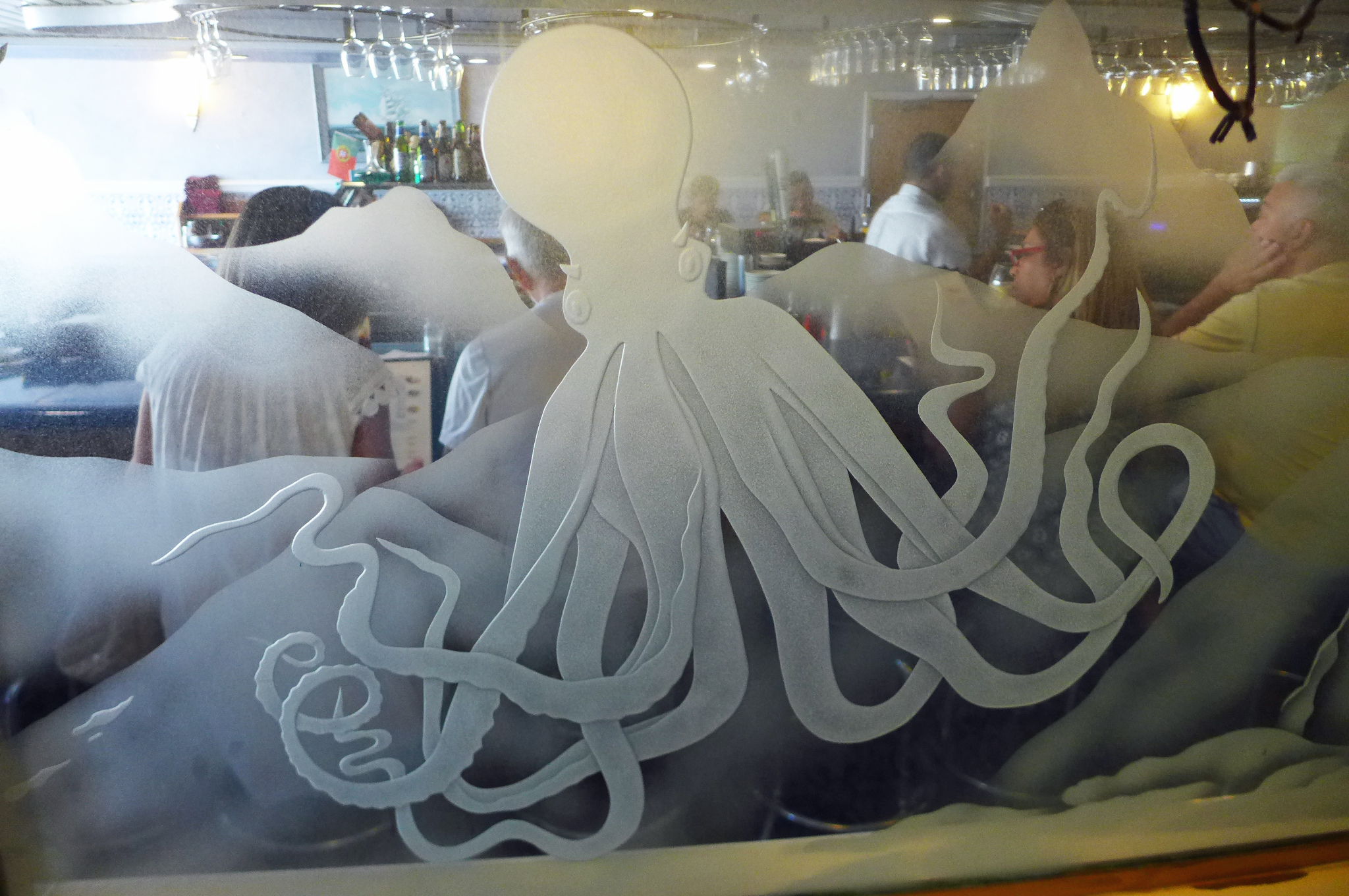 A glass window with an undersea scene etched on it featuring an octopus...