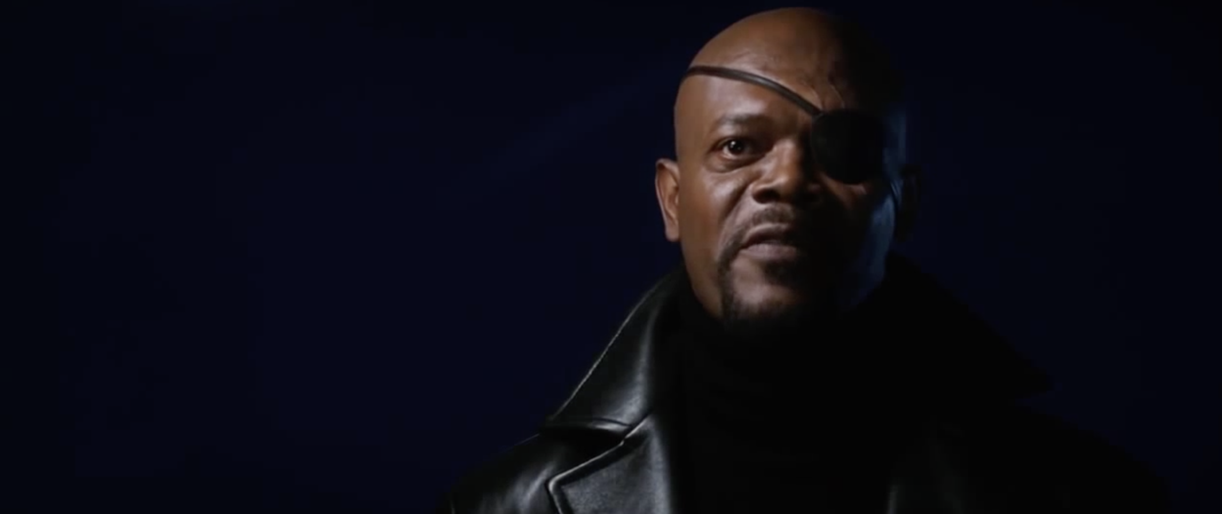 nick fury stares at the camera, his face in shadow