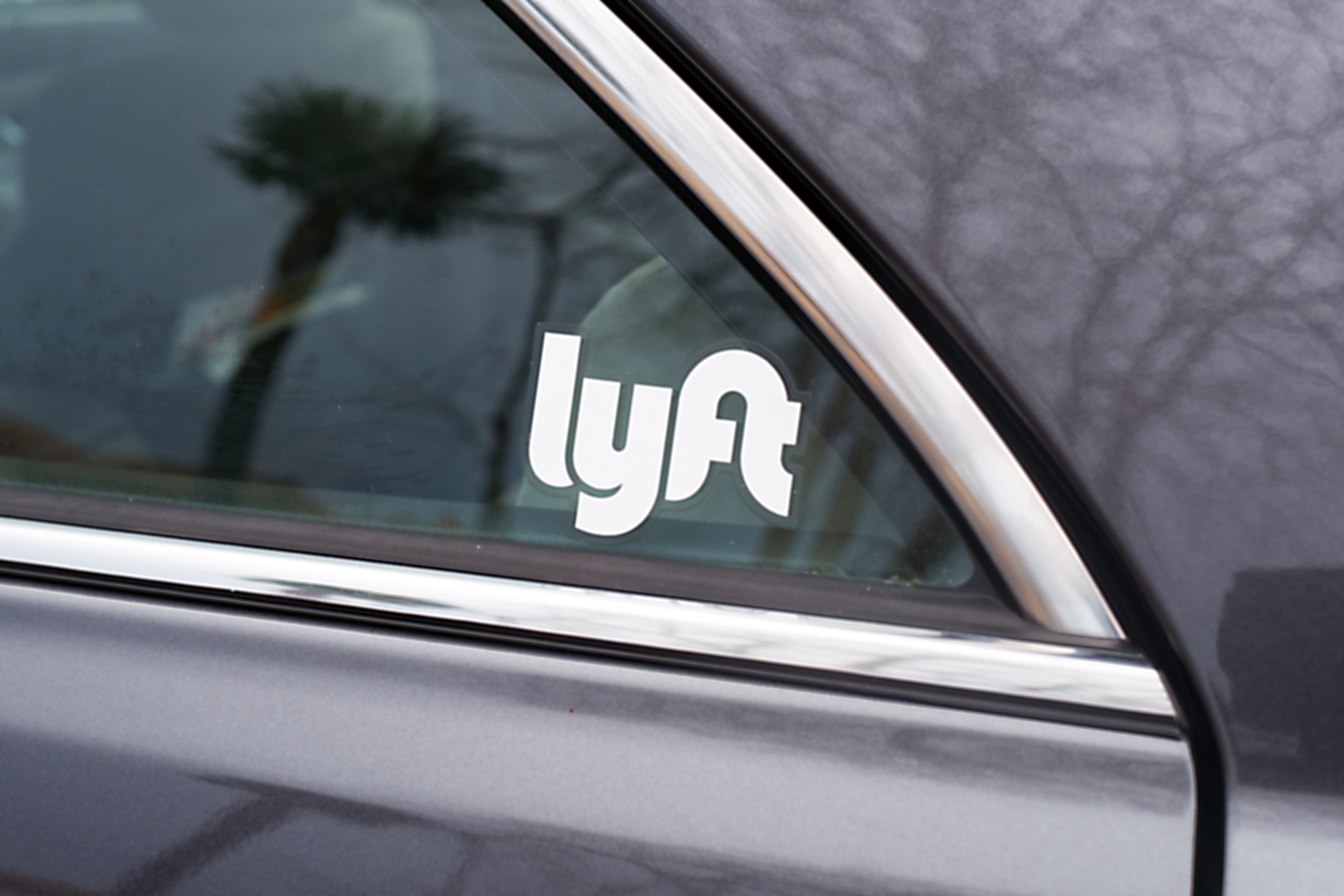 A Lyft sticker on a car window.