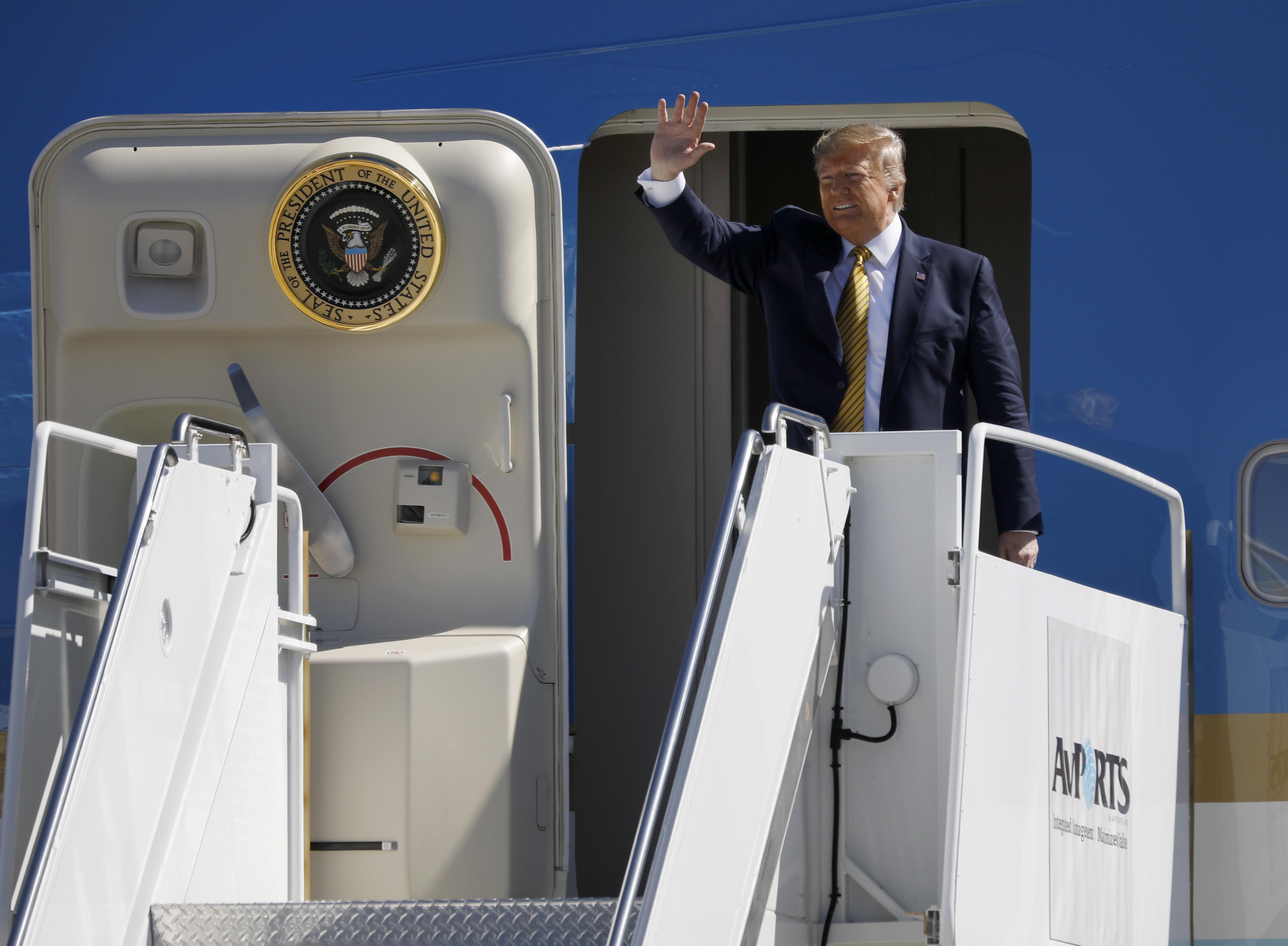 Donald Trump entering Air Force One and waving to an unseen crowd and reporters in Los Angles.