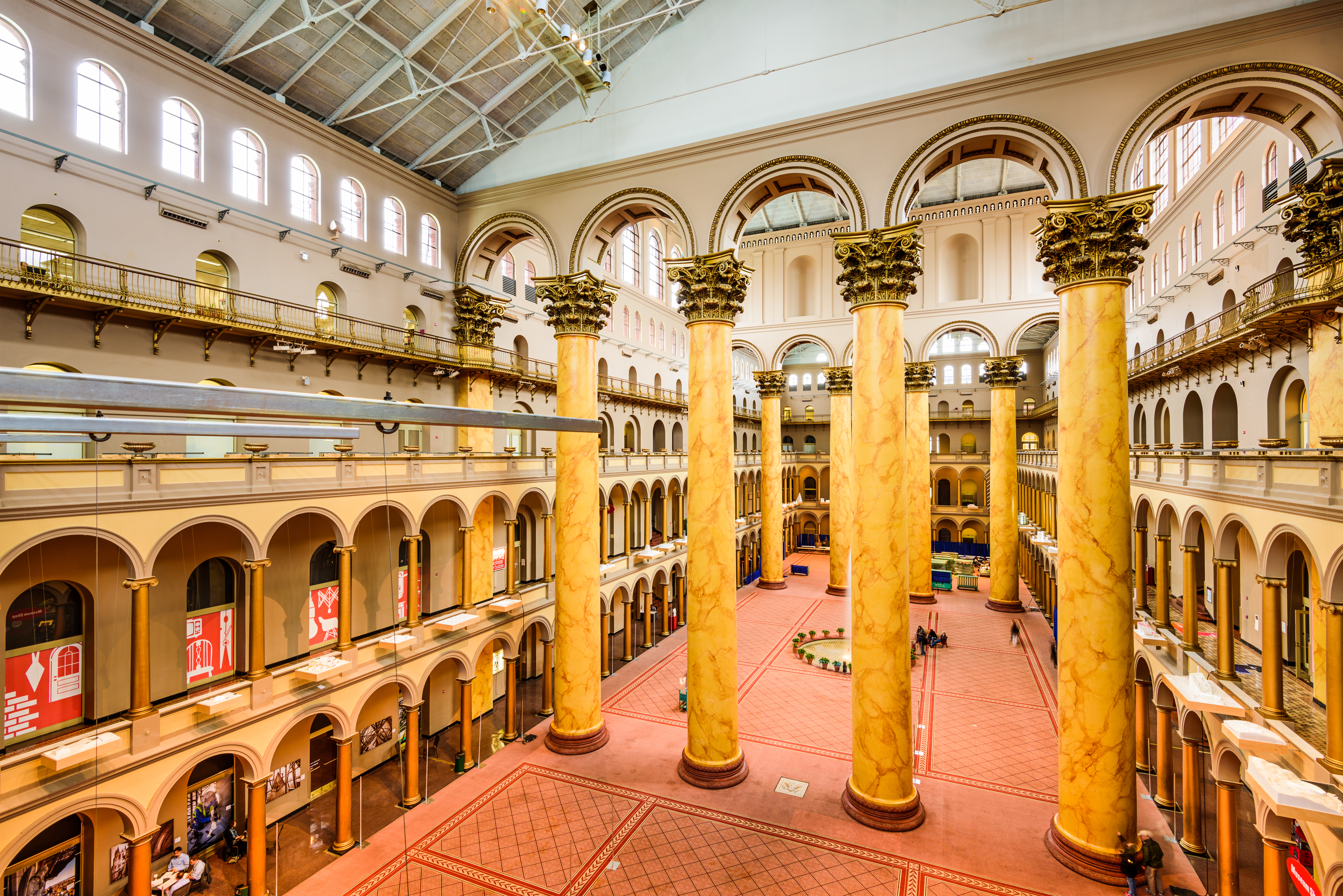 The interior of a Romanesque building. It is a tall space, with large columns, red carpet, and arches.