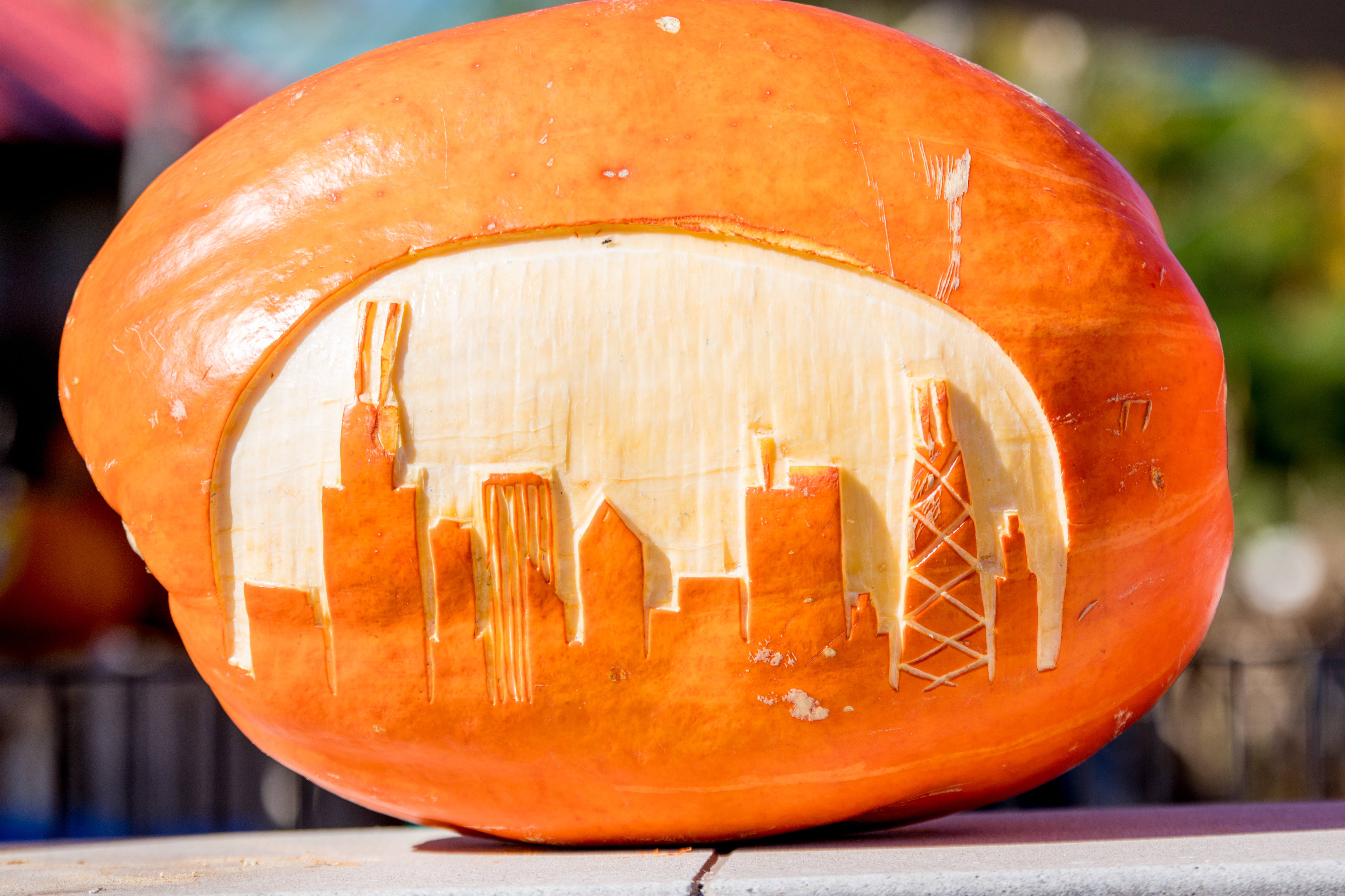 A pumpkin on its side carved with the shape of tall buildings resembling Chicago’s skyline. 