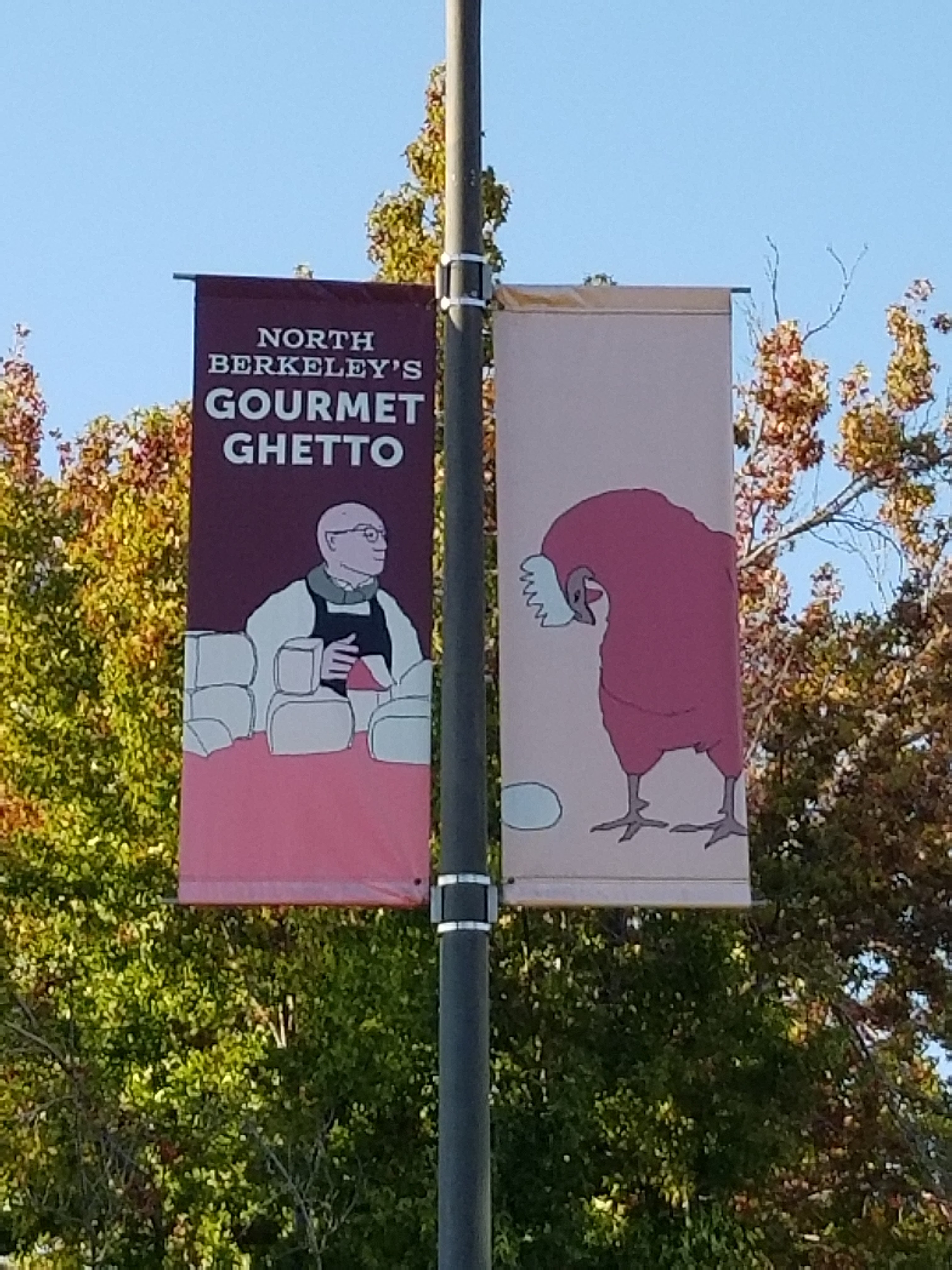 A banner with the phrase “gourmet ghetto” hanging from a lamppost.