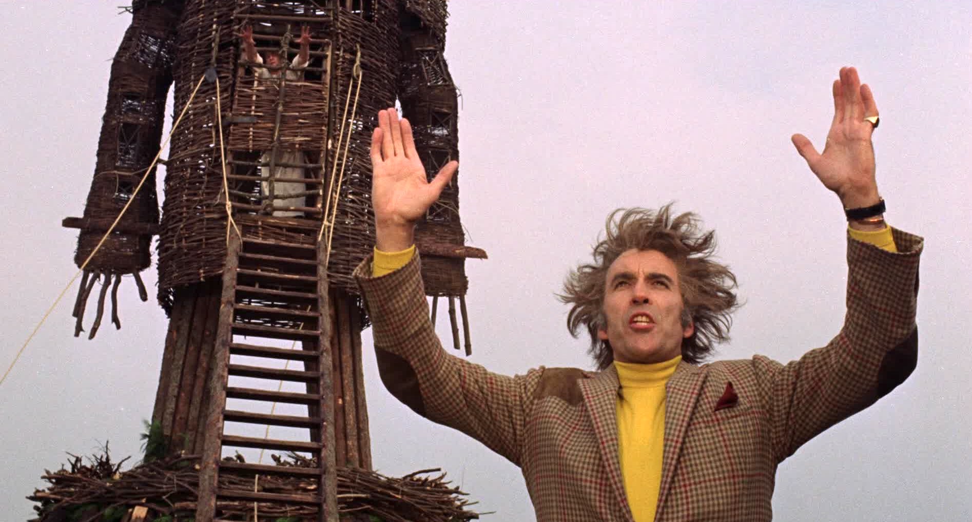 Lord Summerisle holds two hands in the air as he preaches to the crowd and prepares light the wicker man and Sgt. Neil Howie aflame